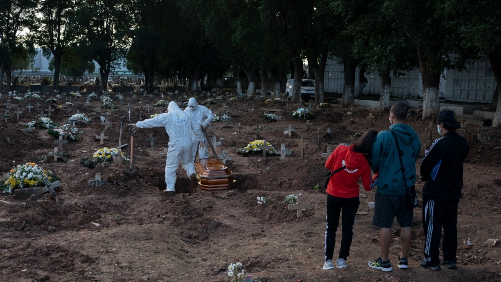 Relatives attend the burial of 71-year-old Neide Rodrigues Rosa, who died from the new coronavirus according to her son Sergio Rodrigues, in Rio de Janeiro on Friday