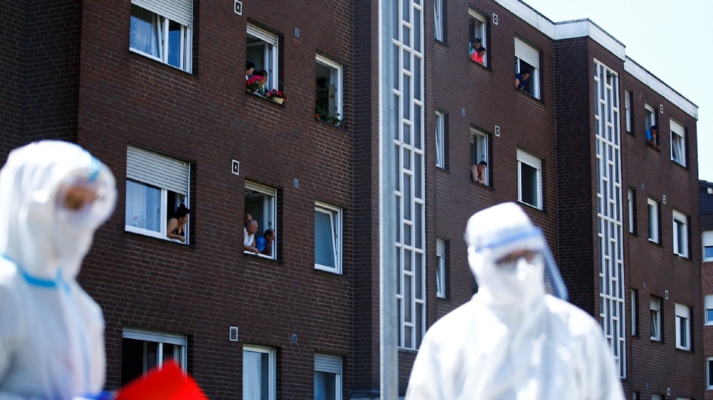 Employees of the Toennies factory, who are under lockdown after a coronavirus disease (COVID-19) outbreak in the meatpacking plant, lean out the windows of their houses in Verl,
