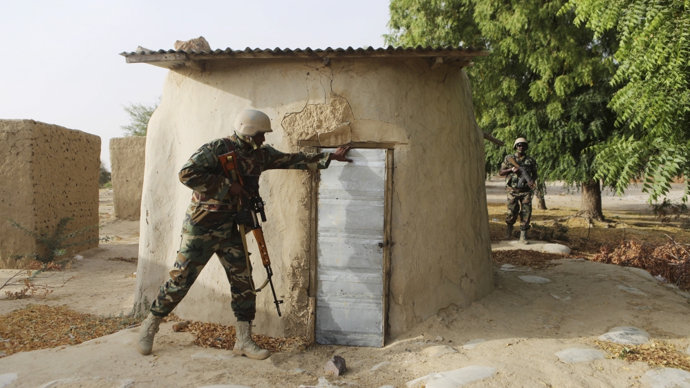 A Nigerien soldier checks a building while on patrol in Duji