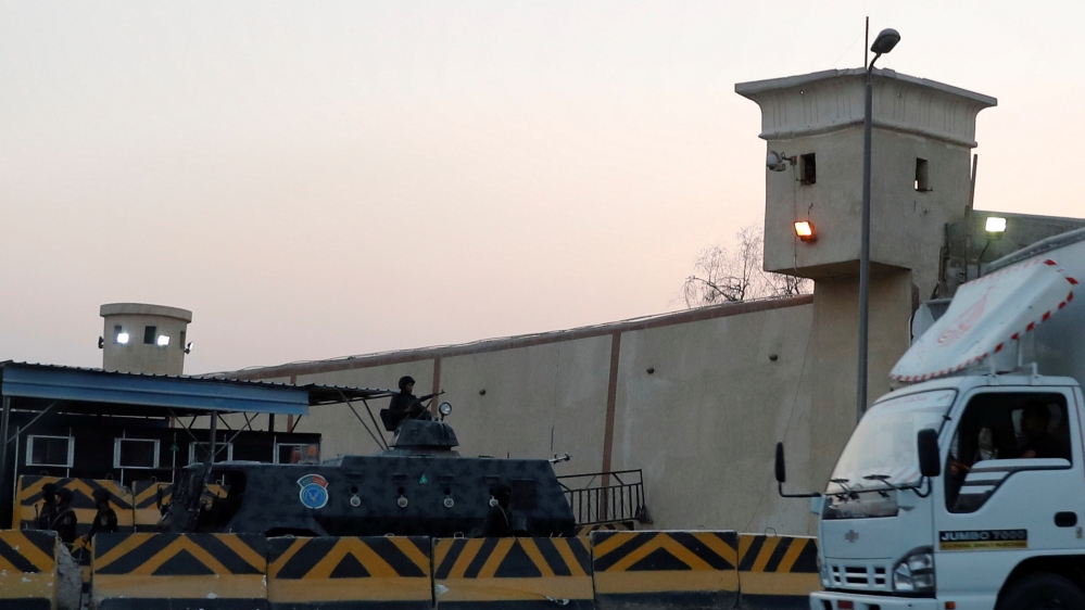 A truck drives in front of security and riot police guards, outside Cairo's Tora prison, where the trial of ousted Egyptian Islamist President Mohamed Mursi took place, in Cairo