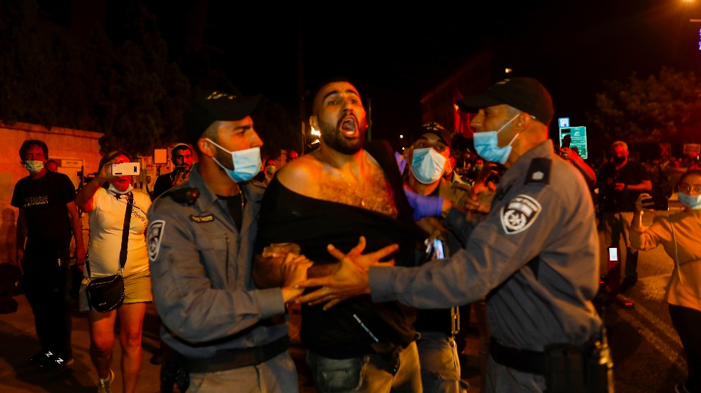 ISRAEL-POLITICS-PROTEST A protester is detained by Israeli police during a demonstration against Israeli Prime Minister Benjamin Netanyahu outside his official residence in Jerusalem