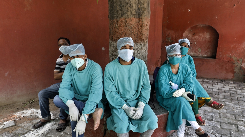 Health workers take rest at the Tej Bahadur Sapru Hospital in Prayagraj, India, Wednesday, July 22, 2020. With a surge in coronavirus cases in the past few weeks, state governments in India have been