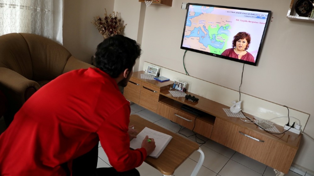 FILE PHOTO: Sinan Guldure, a 16-year old high school student, watches a history leasson on television as part of home schooling during the coronavirus disease (COVID-19) outbreak,
