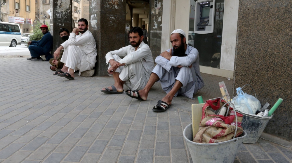 Foreign workers sit on the street after reportedly losing their jobs following the outbreak of the coronavirus disease in Riyadh