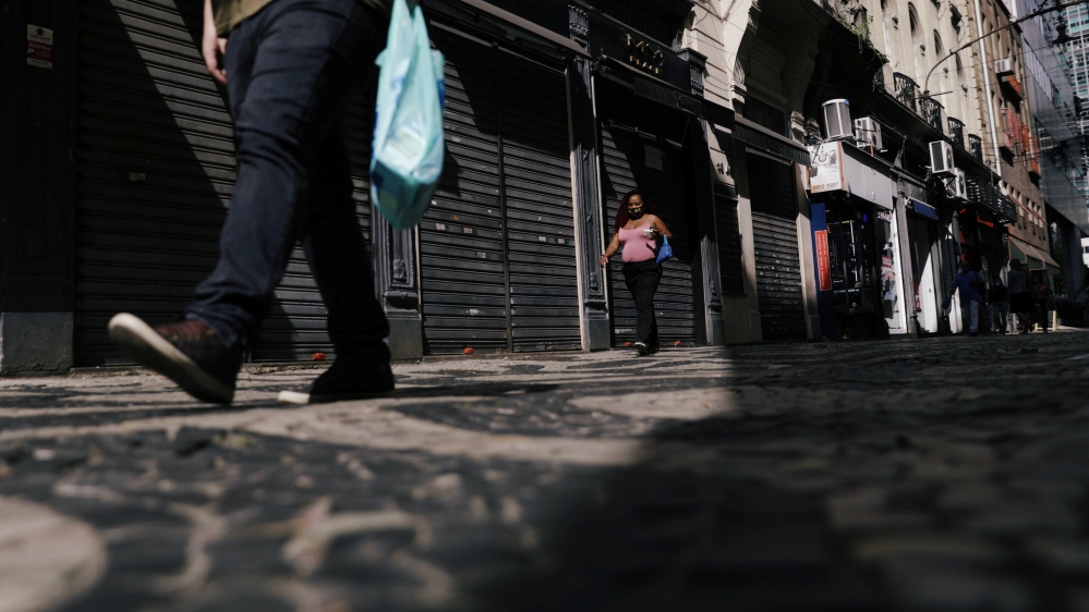 People walk past closed stores in Rio de Janeiro’s downtown, Brazil
