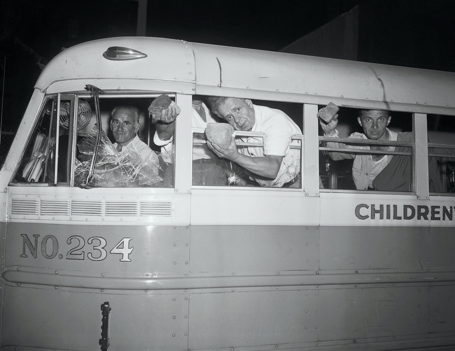 Passengers hold up some of the rocks that battered their bus as they left the concert grounds in Peekskill