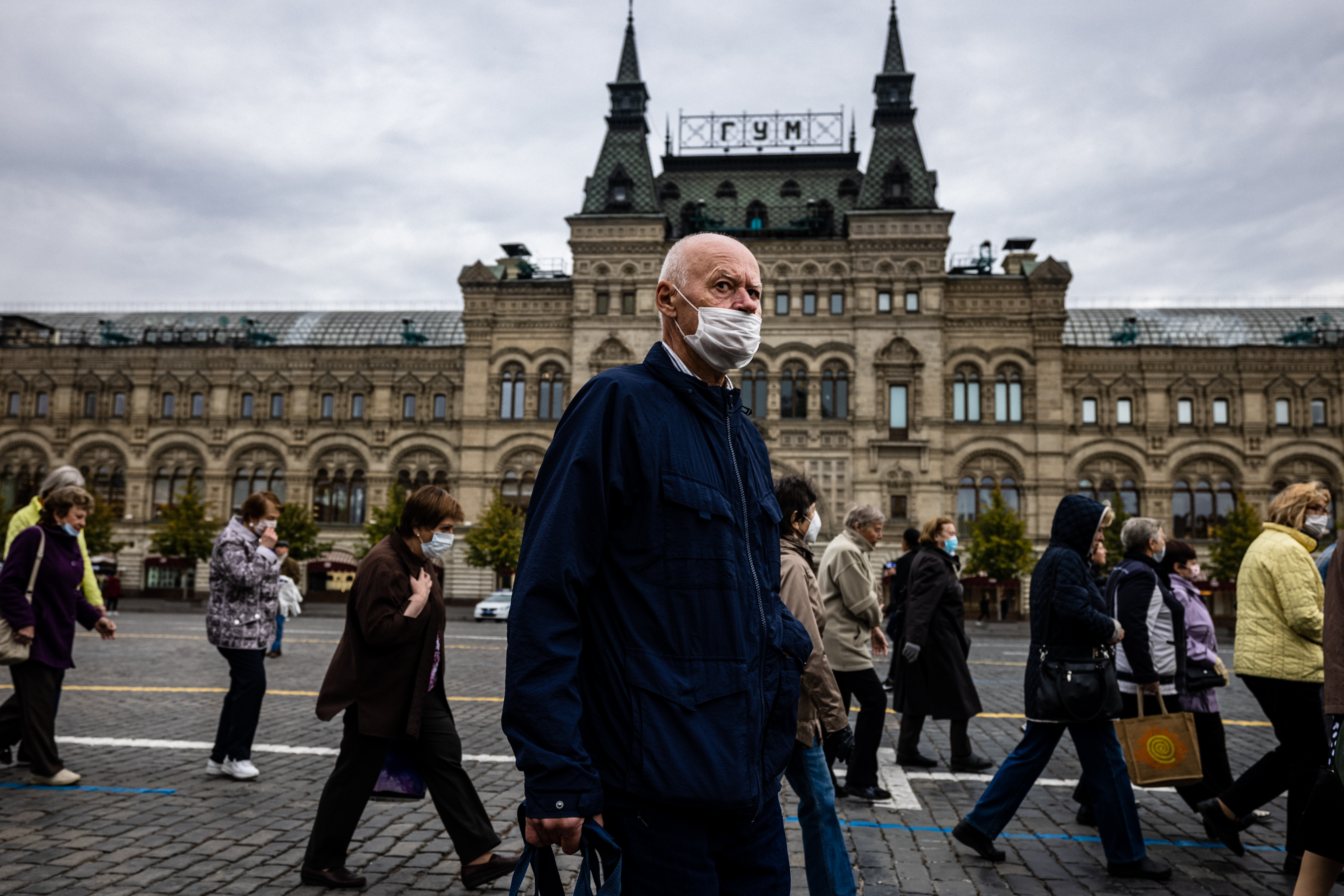 A man wearing a face mask to protect against the coronavirus disease walks on Red Square in front of the GUM department store in central Moscow