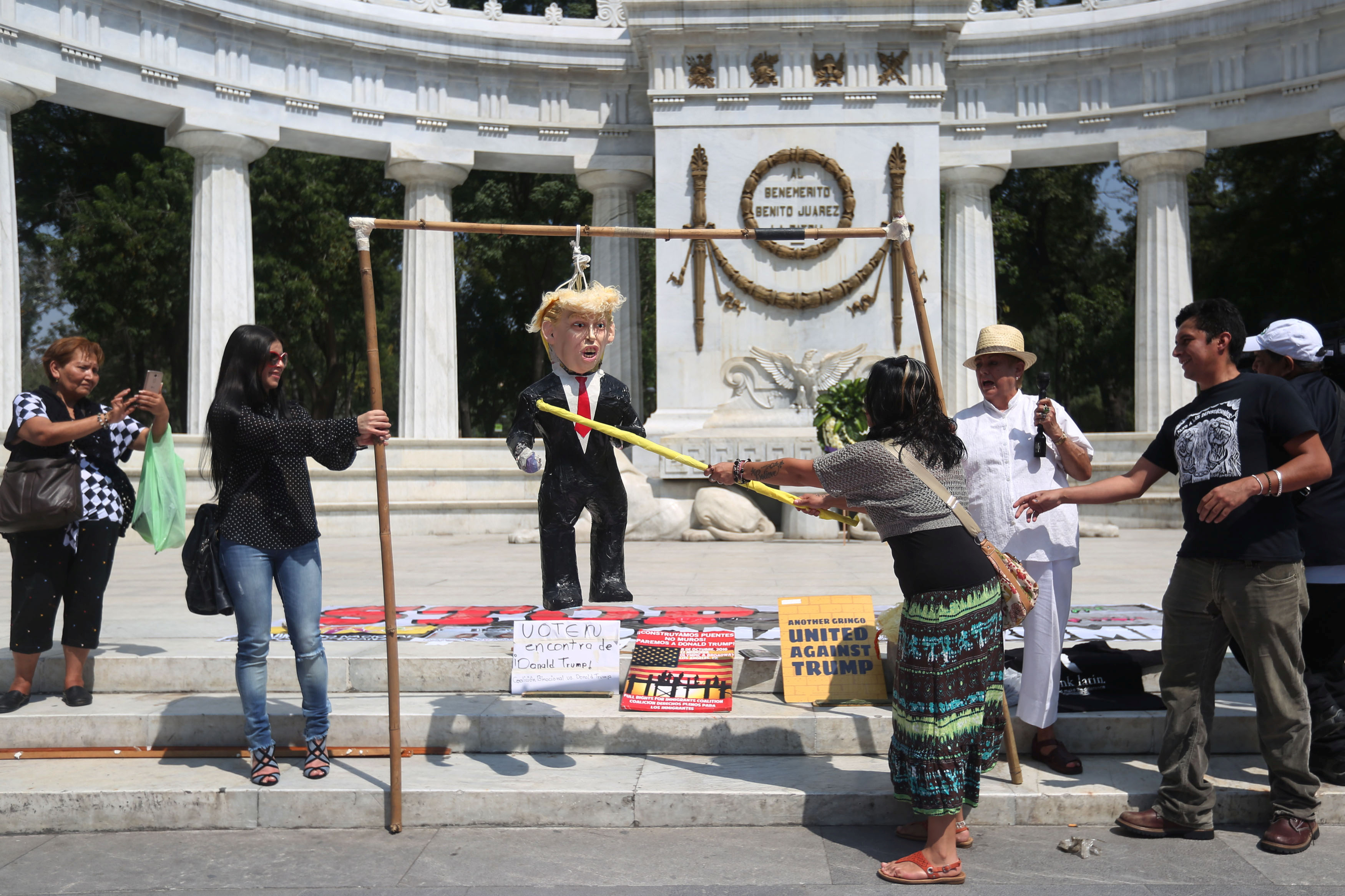 An activist hits a pinata of US President Donald Trump, back in 2016 when he was candidate Trump, during a protest at Hemiciclo a Juarez monument in Mexico City, Mexico