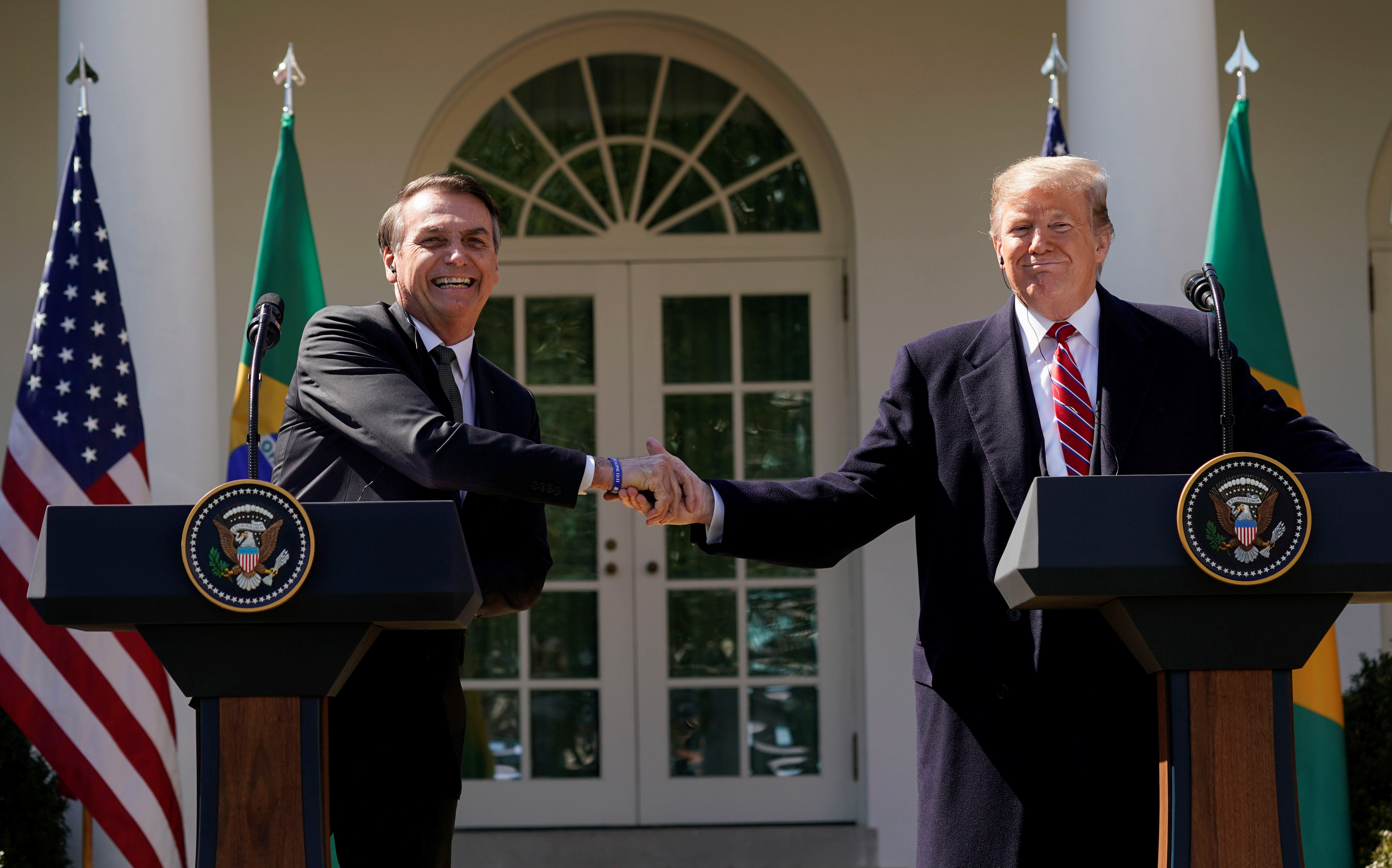 Brazil’s President Jair Bolsonaro shakes hands with US President Donald Trump in 2019