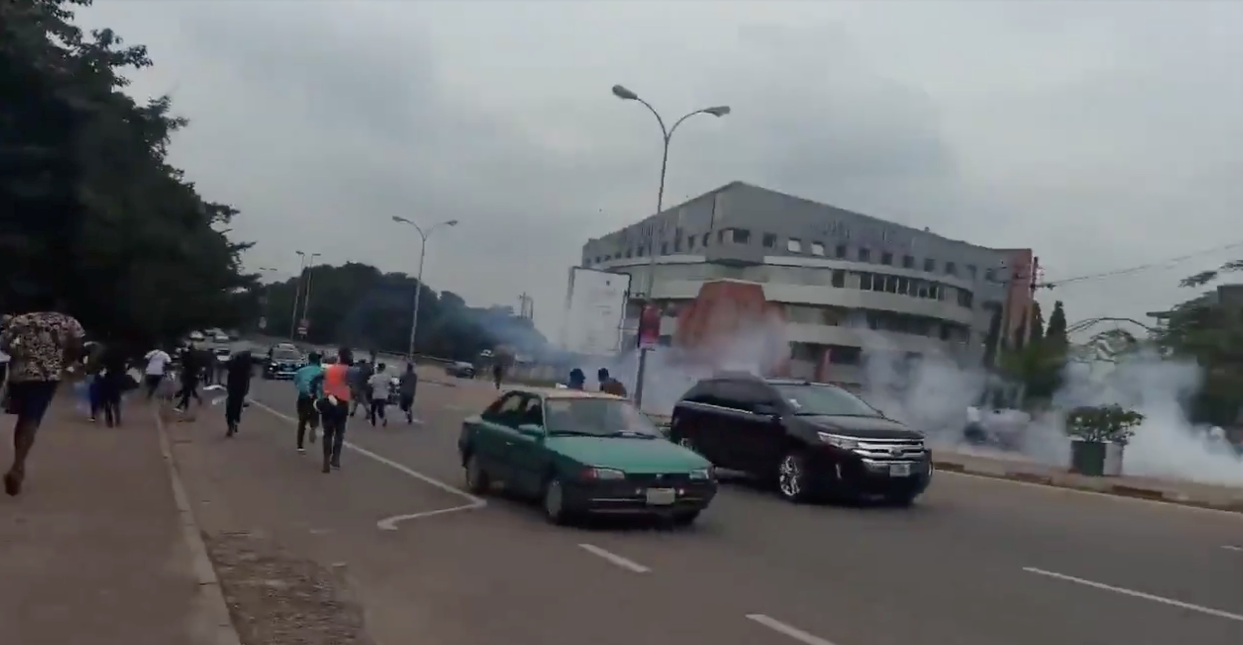 People run during a protest in Abuja on Friday