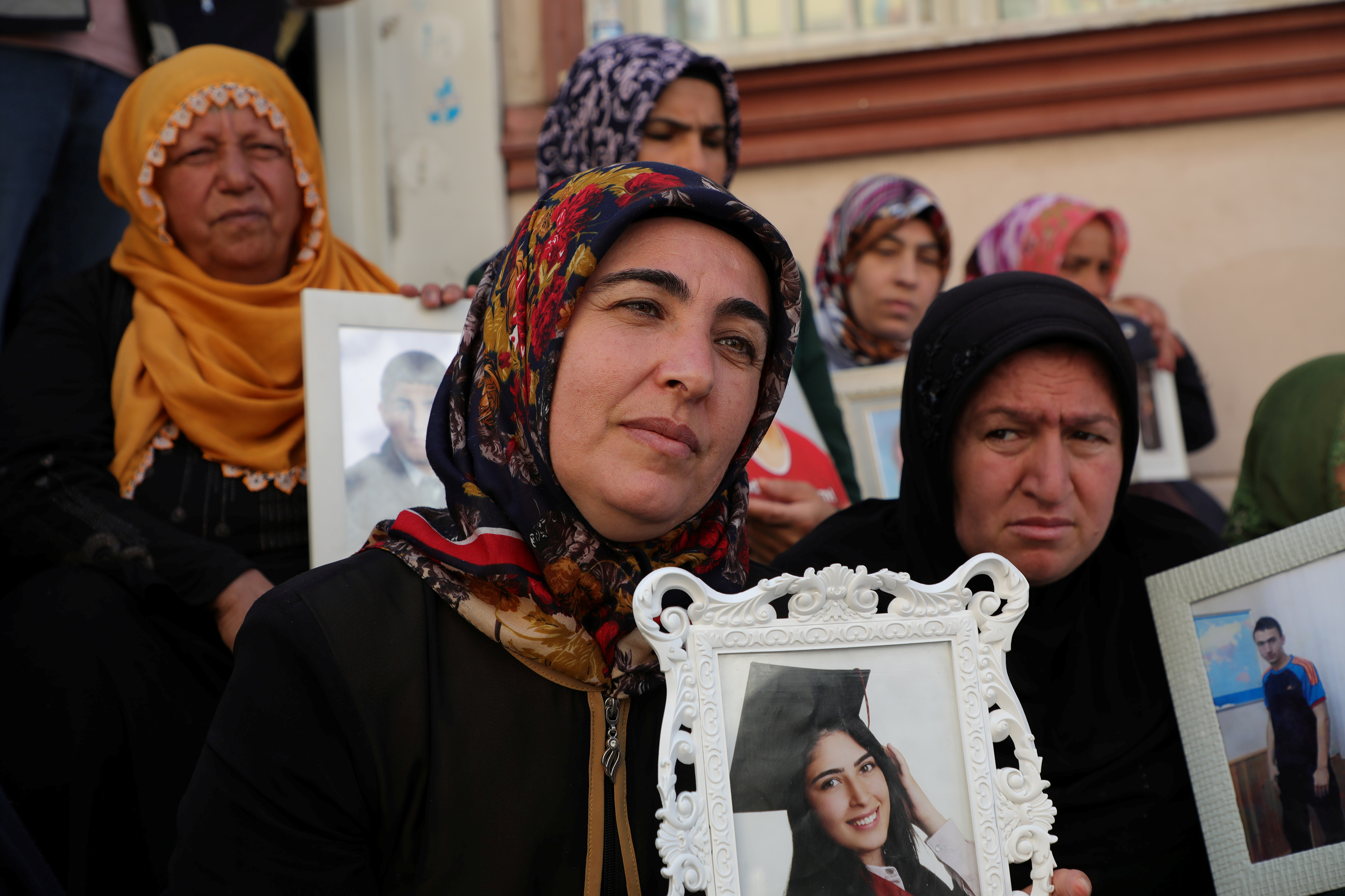 Turkan Mutlu holds a photo of her daughter Ceylan who joined the PKK during a sit-in protest outside the HDP headquarters in Diyarbakir on October 17, 2019 [File: Sertac Kayar/Reuters]