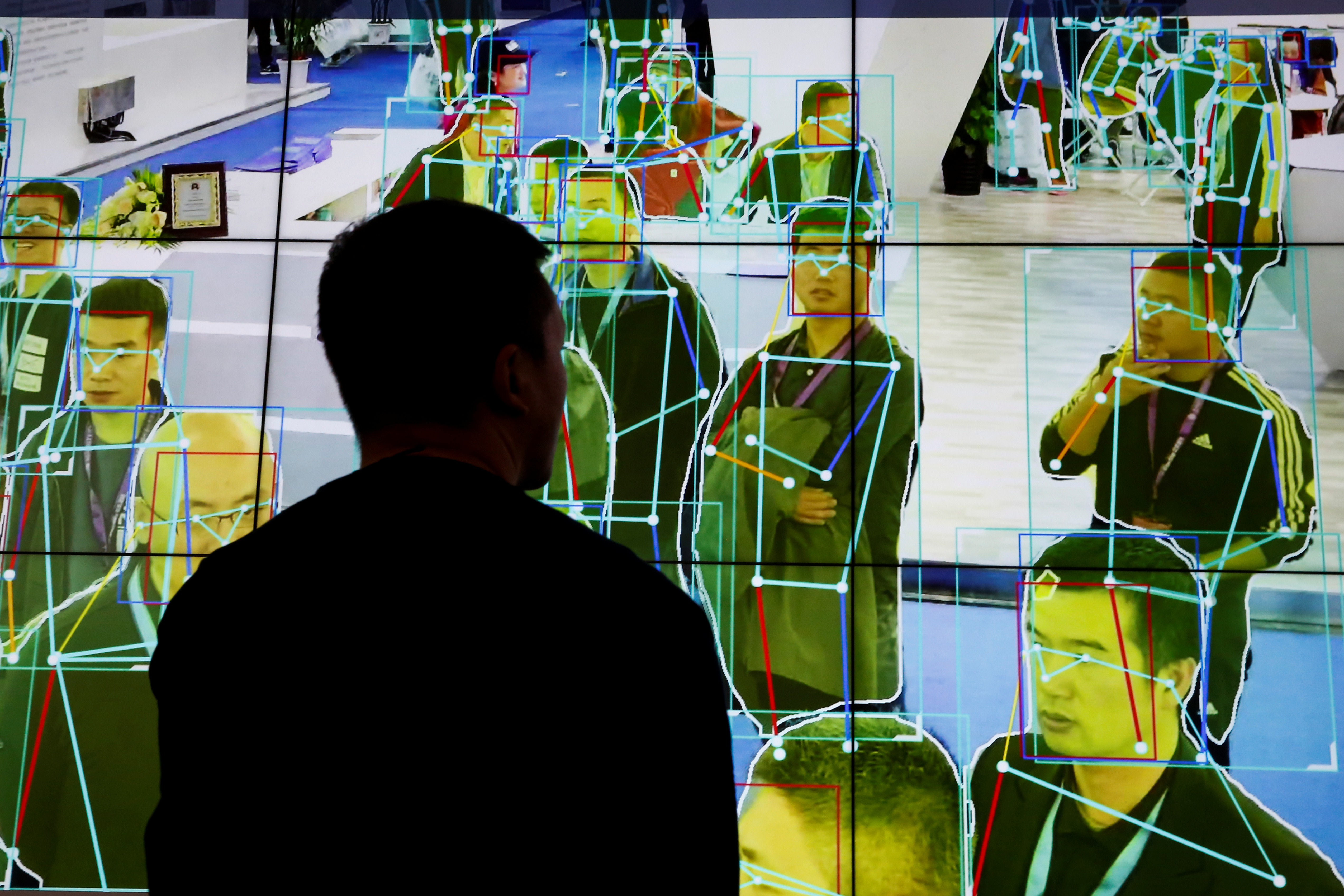 A man looks at a demonstration of human motion analysis software at the stall of an artificial intelligence solutions maker at an exhibition in China