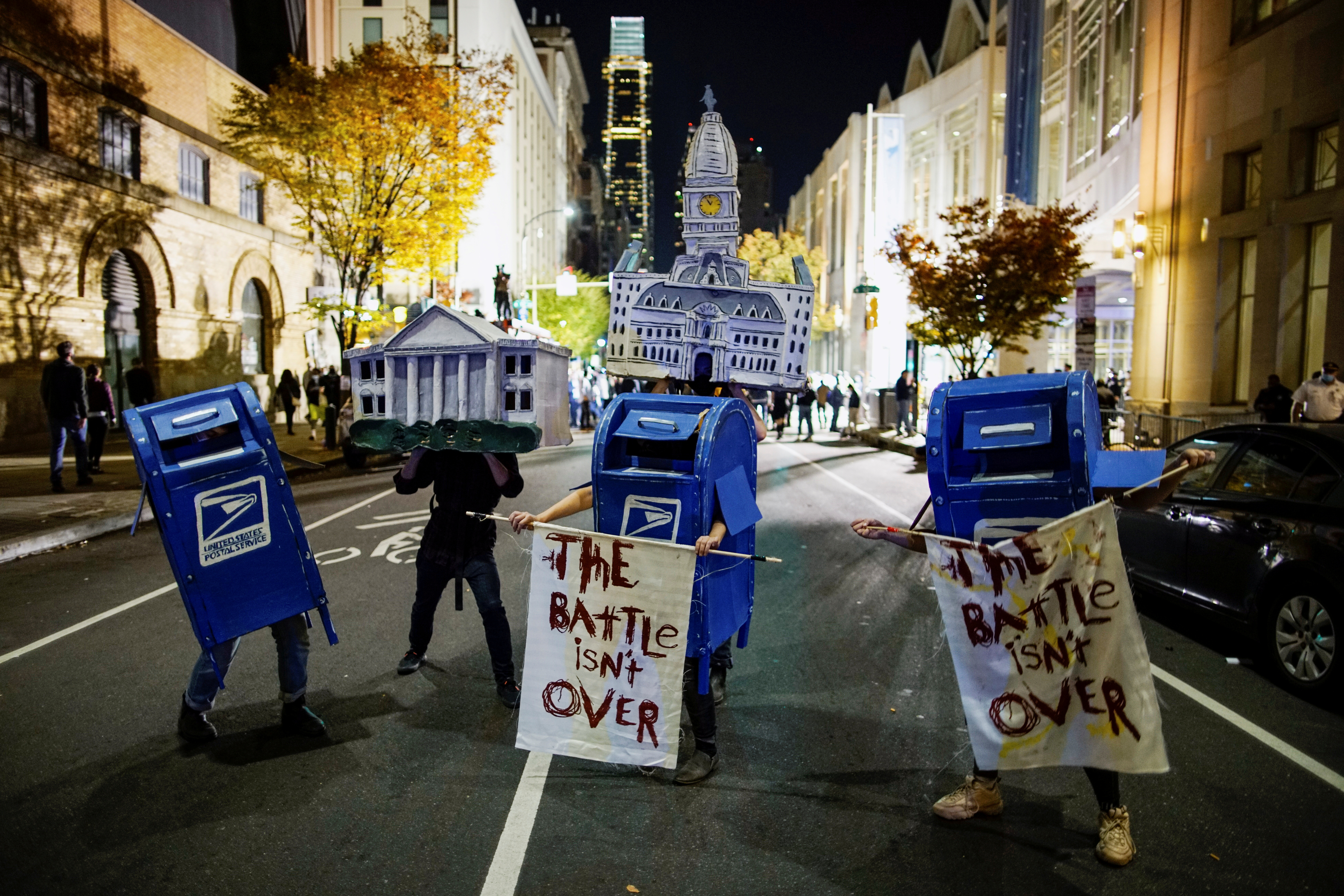 Activists dressed as the White House, Philadelphia City Hall and the US Postal Service mailboxes stand on a street two days after the presidential election in Philadelphia, Pennsylvania