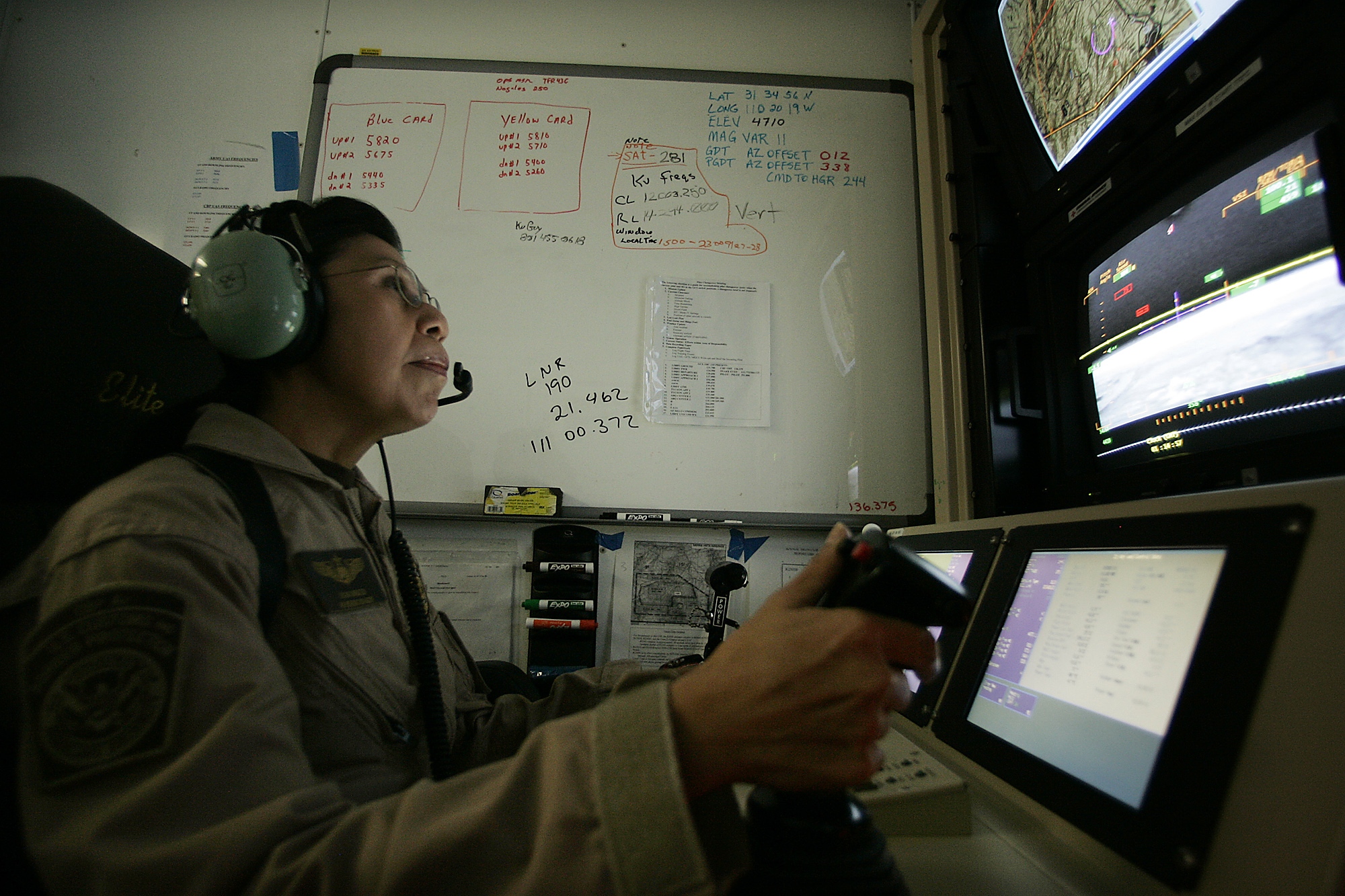 An American military pilot flies a Predator drone from a ground command post during a night border mission