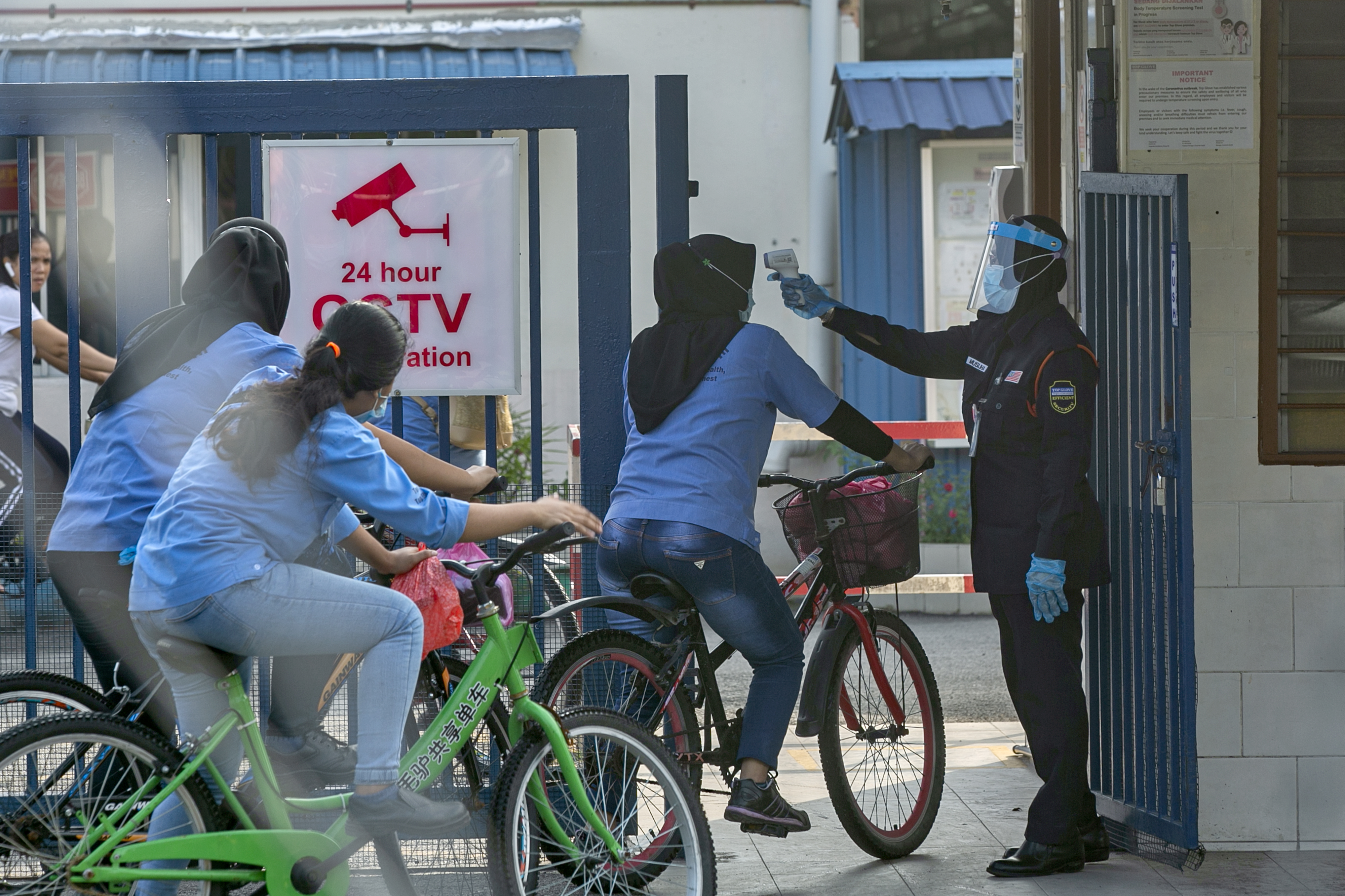 Staff temperatures are checked on their arrival at a Top Glove hostel for female workers