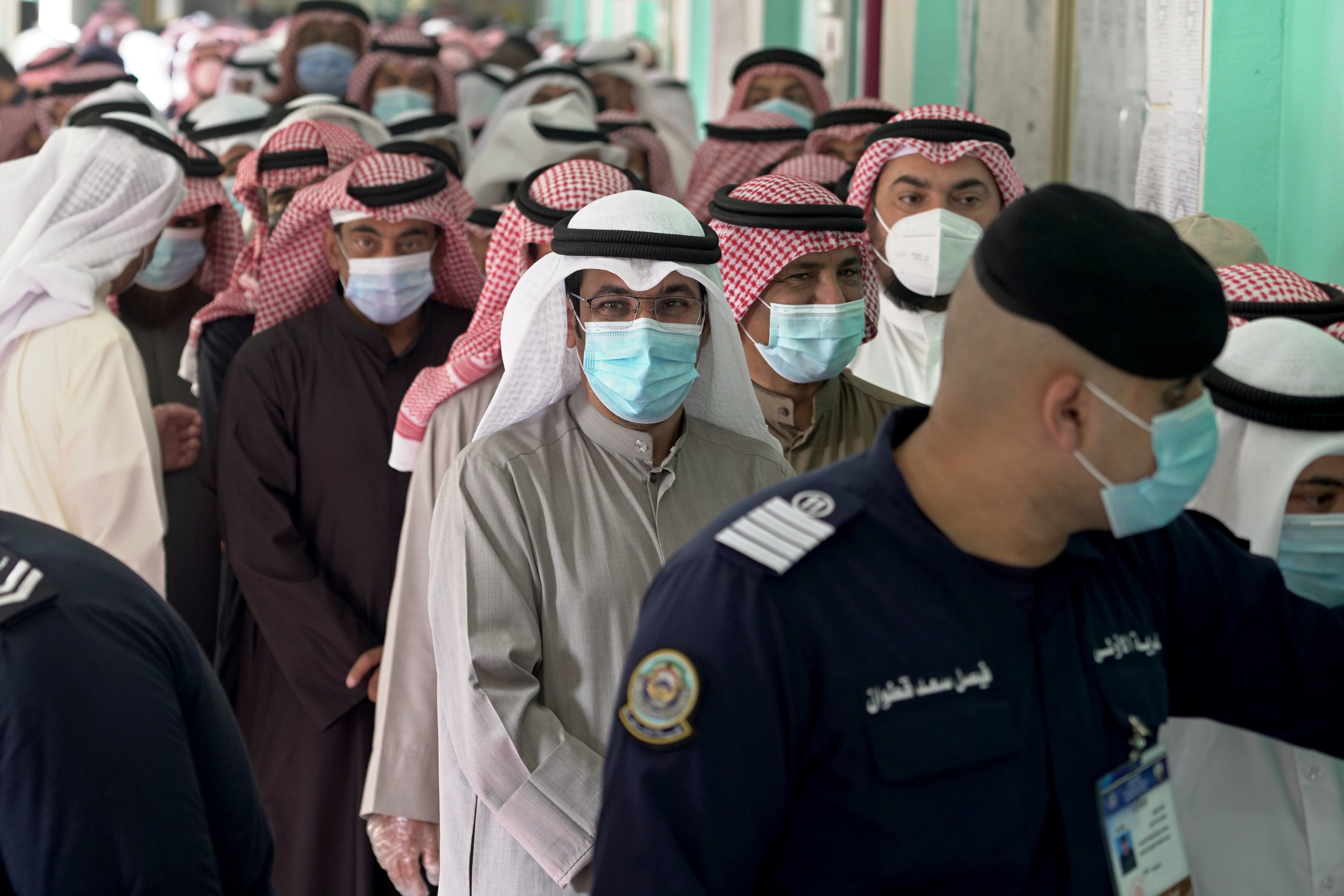 Kuwaitis stand in a crowed hall waiting to vote during parliamentary elections in Jahra City, Kuwait