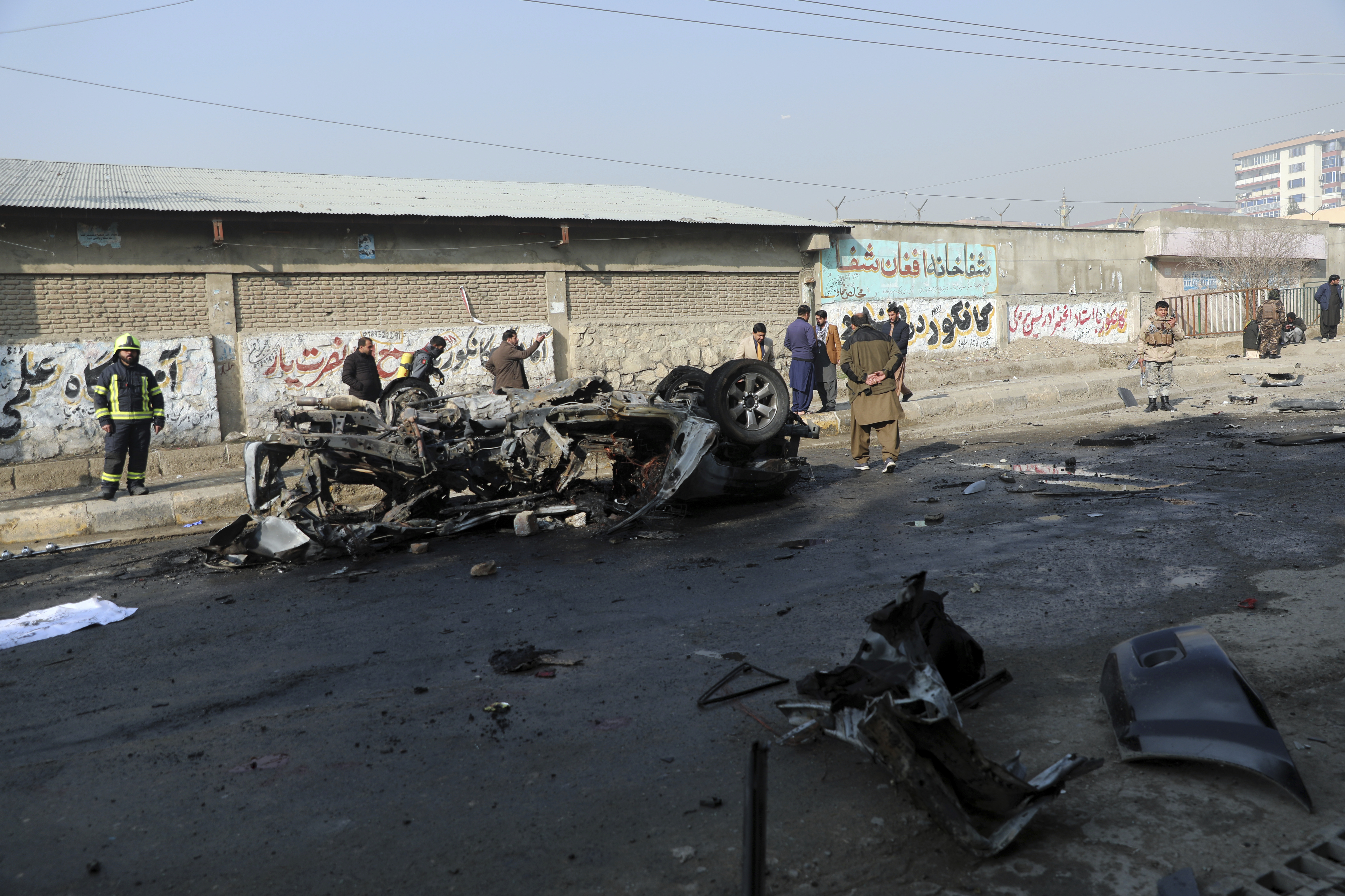 Afghan security officers inspect the site of a bombing in Kabul, Afghanistan