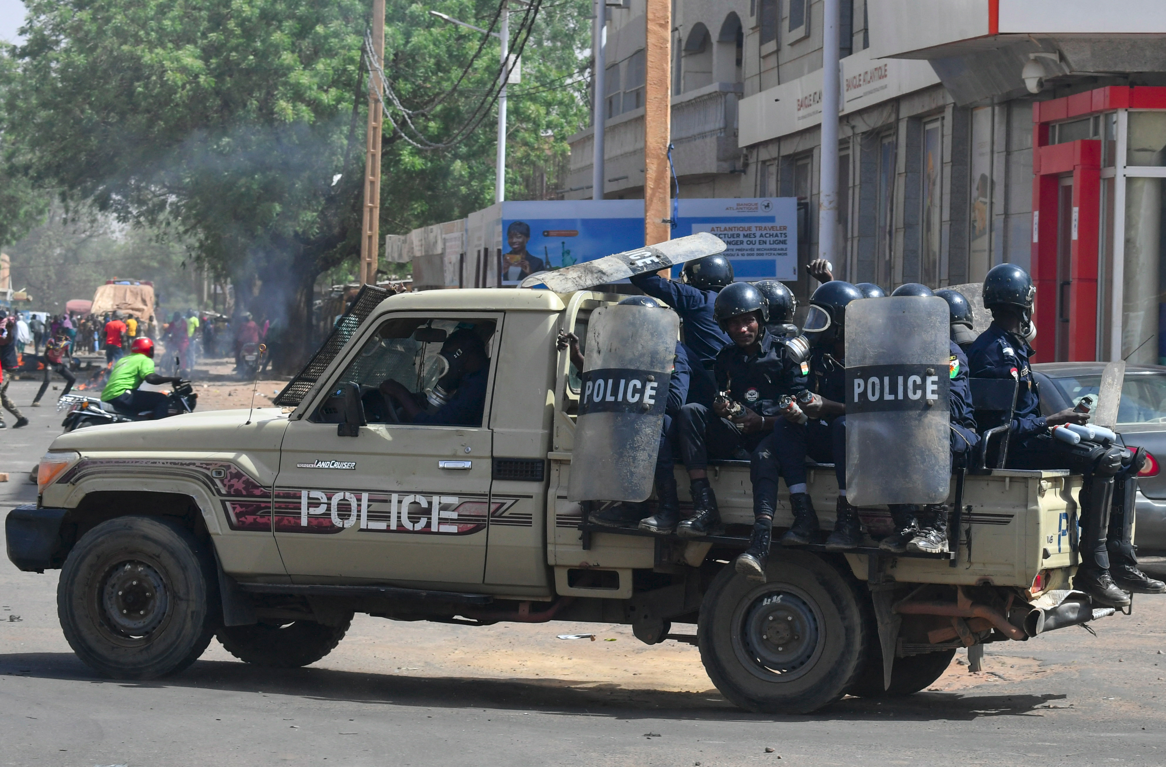 Riot police officers patrol on a pickup truck during clashes with demonstrators