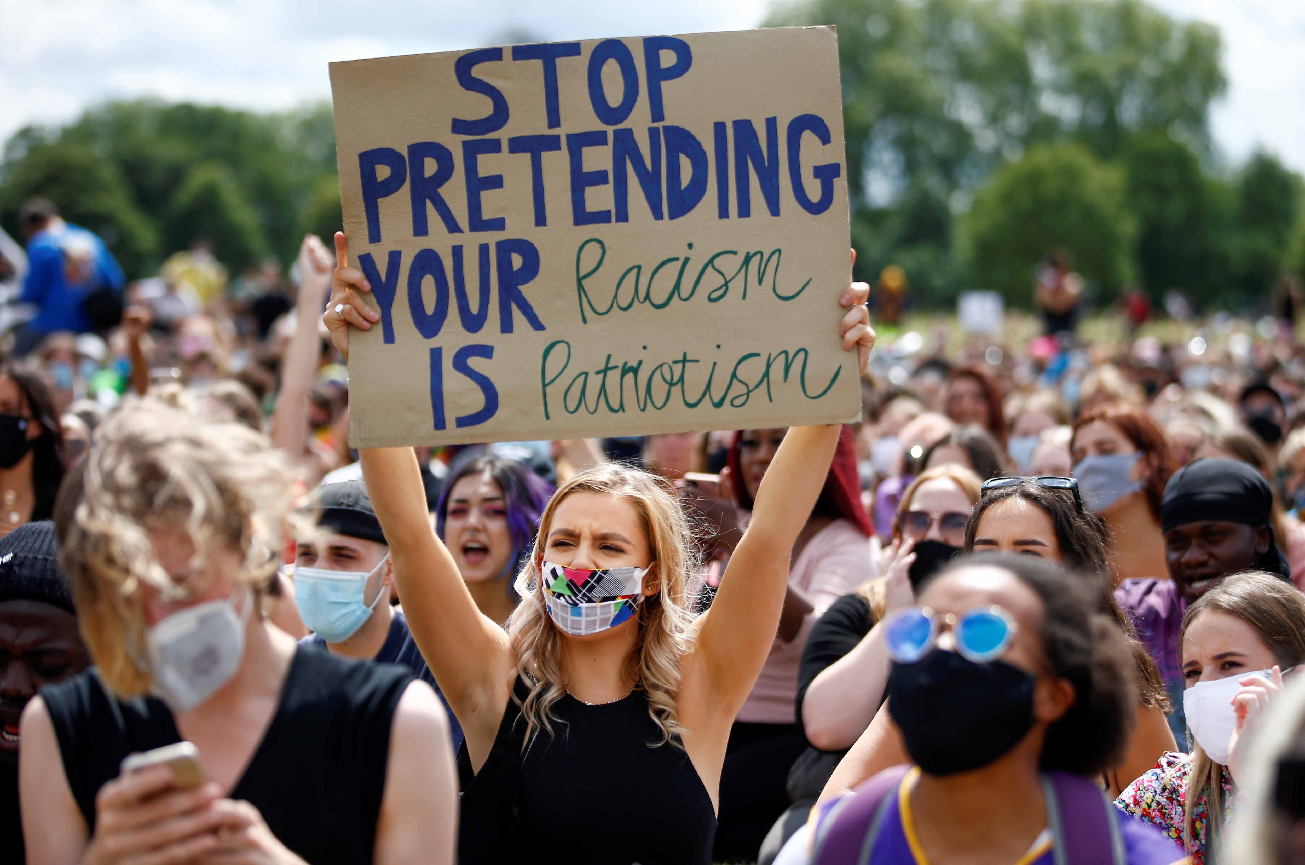 A demonstrator holds a placard as she attends a Black Lives Matter protest at Hyde Park, following the death of American citizen George Floyd in Minneapolis police custody, in London, Britain on June 20, 2020 [File: Reuters/Henry Nicholls]