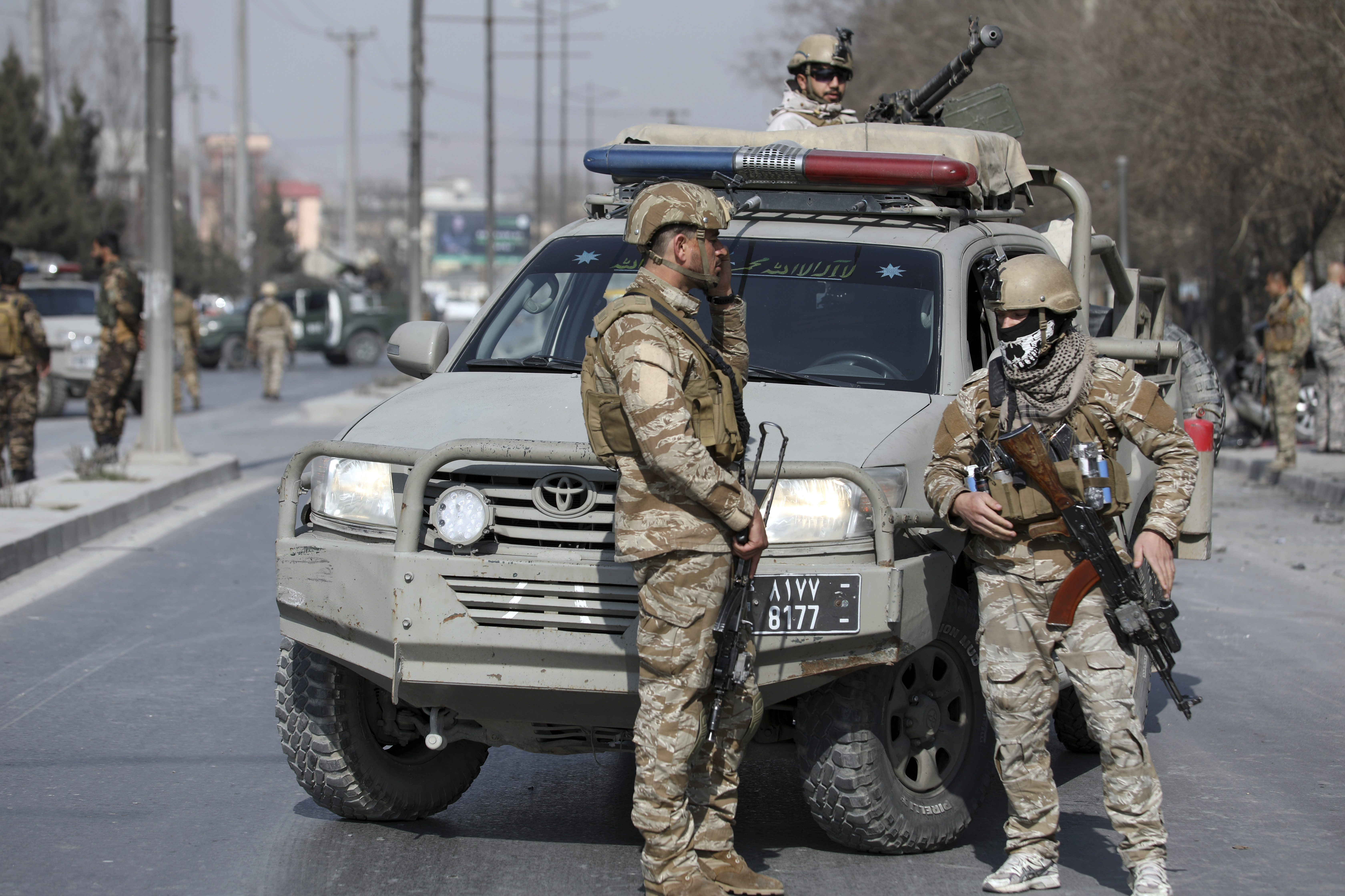 Afghan security personnel inspect the site of a deadly bomb attack in Kabul