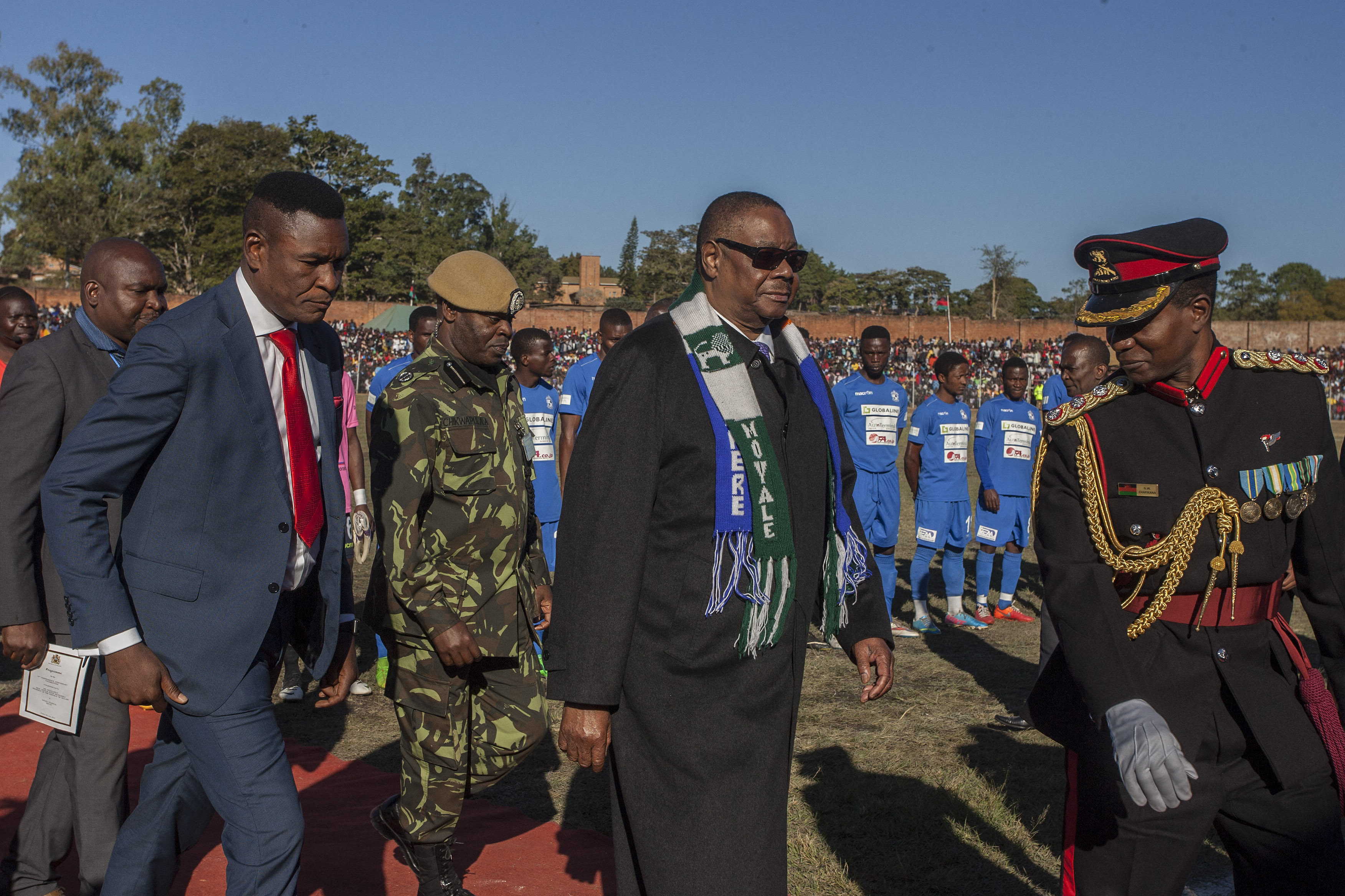 Former Malawian President Peter Mutharika (centre) and his bodyguard Norman Chisale (left) at independence anniversary celebrations in 2018 [File: Amos Gumulira/AFP]