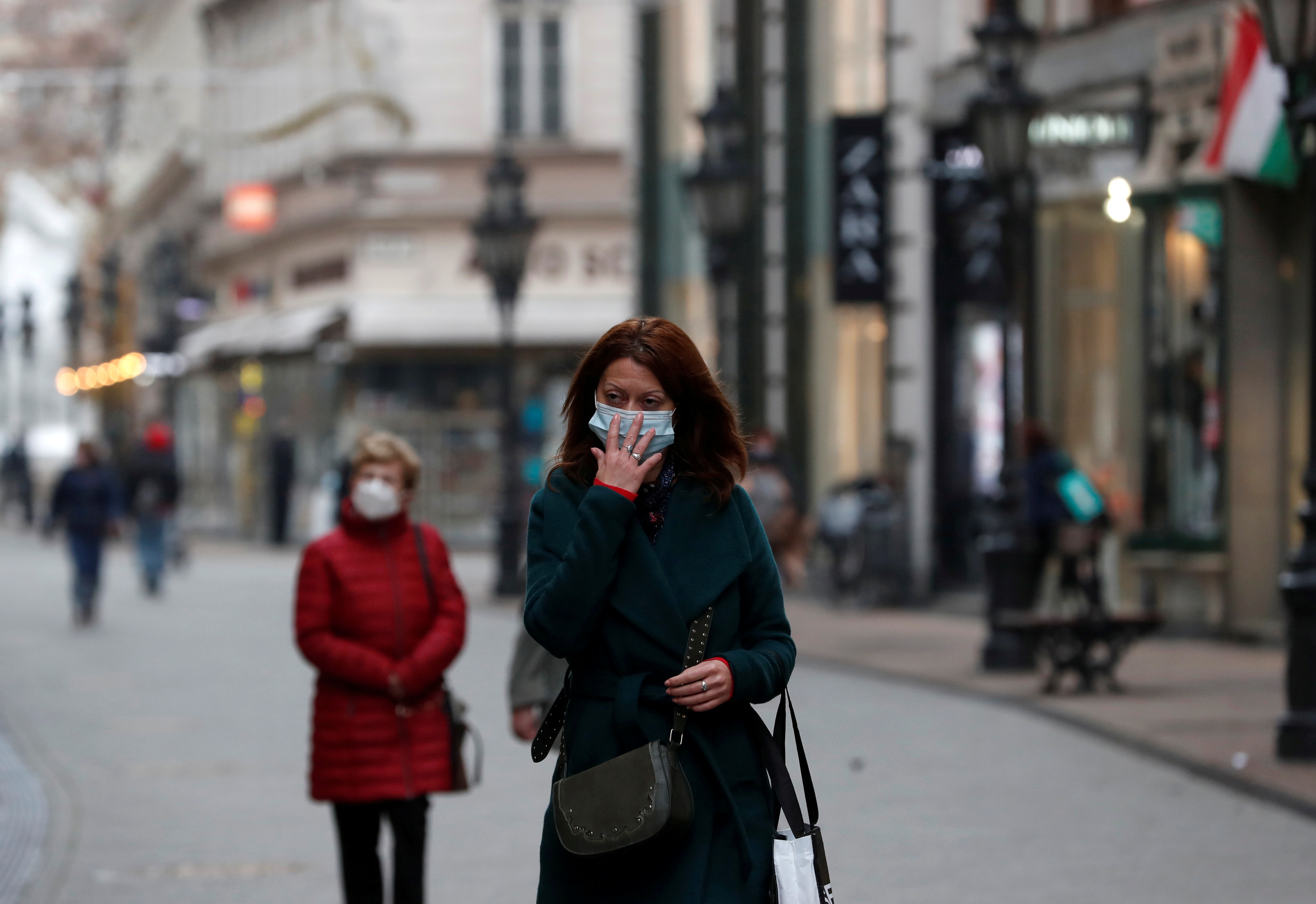 People wearing protective face masks walk in downtown Budapest, after the Hungarian government imposed a nationwide lockdown to contain the spread of the coronavirus disease