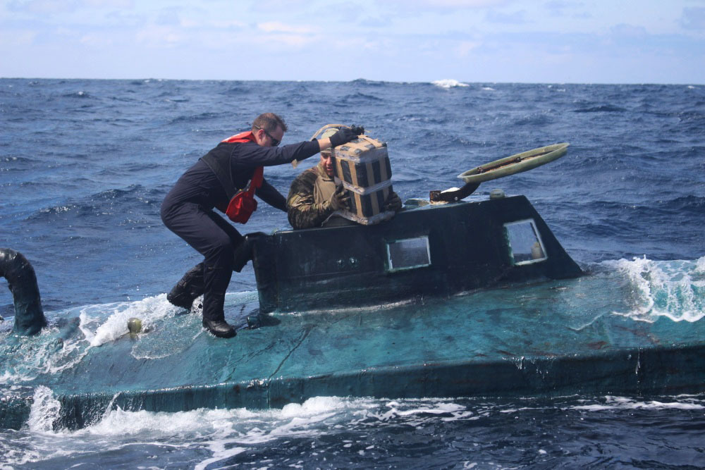This September 2019 photo made available by the US Coast Guard, shows crew members of the cutter Valiant as they board a self-propelled semi-submersible in international waters. The US Coast Guard says a cutter seized a ‘narco’ submarine carrying cocaine worth a street value of more than $165m while patrolling in the eastern Pacific Ocean [US Coast Guard via AP)