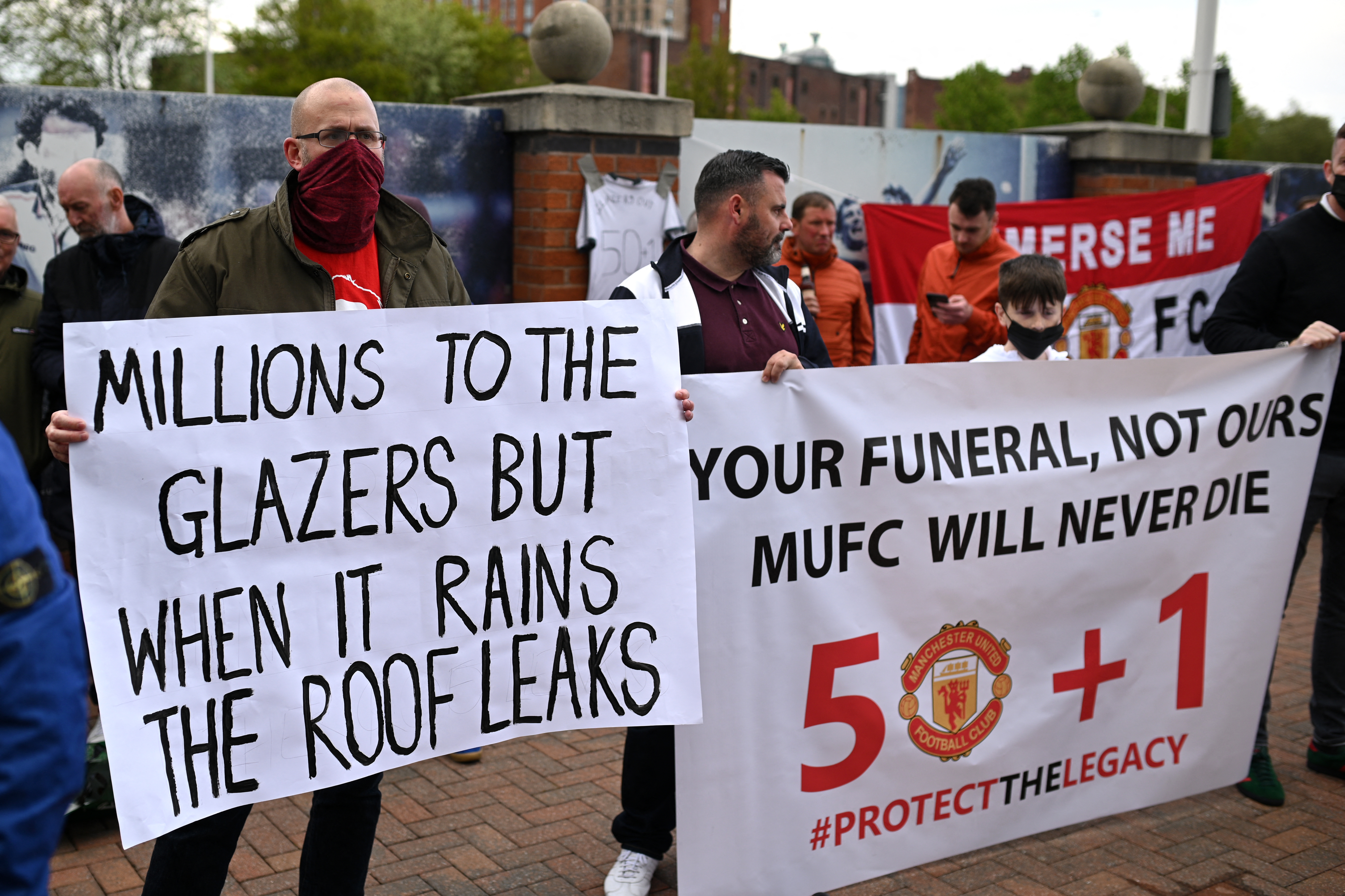 Supporters hold up banners as they protest against Manchester United's owners, outside the Premier League club's Old Trafford stadium [File: Oli Scarff/AFP]