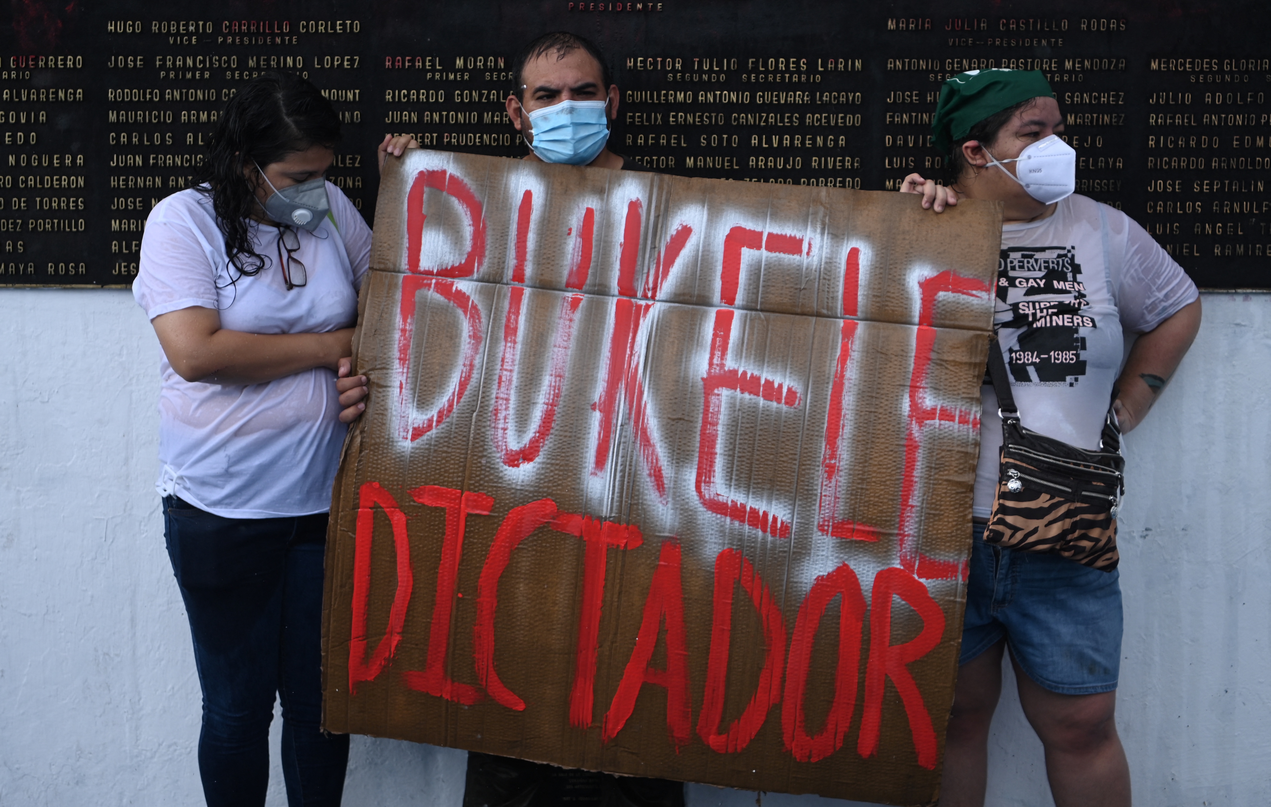 Demonstrators hold a sign reading ‘Bukele Dictator’ during a protest on May 2