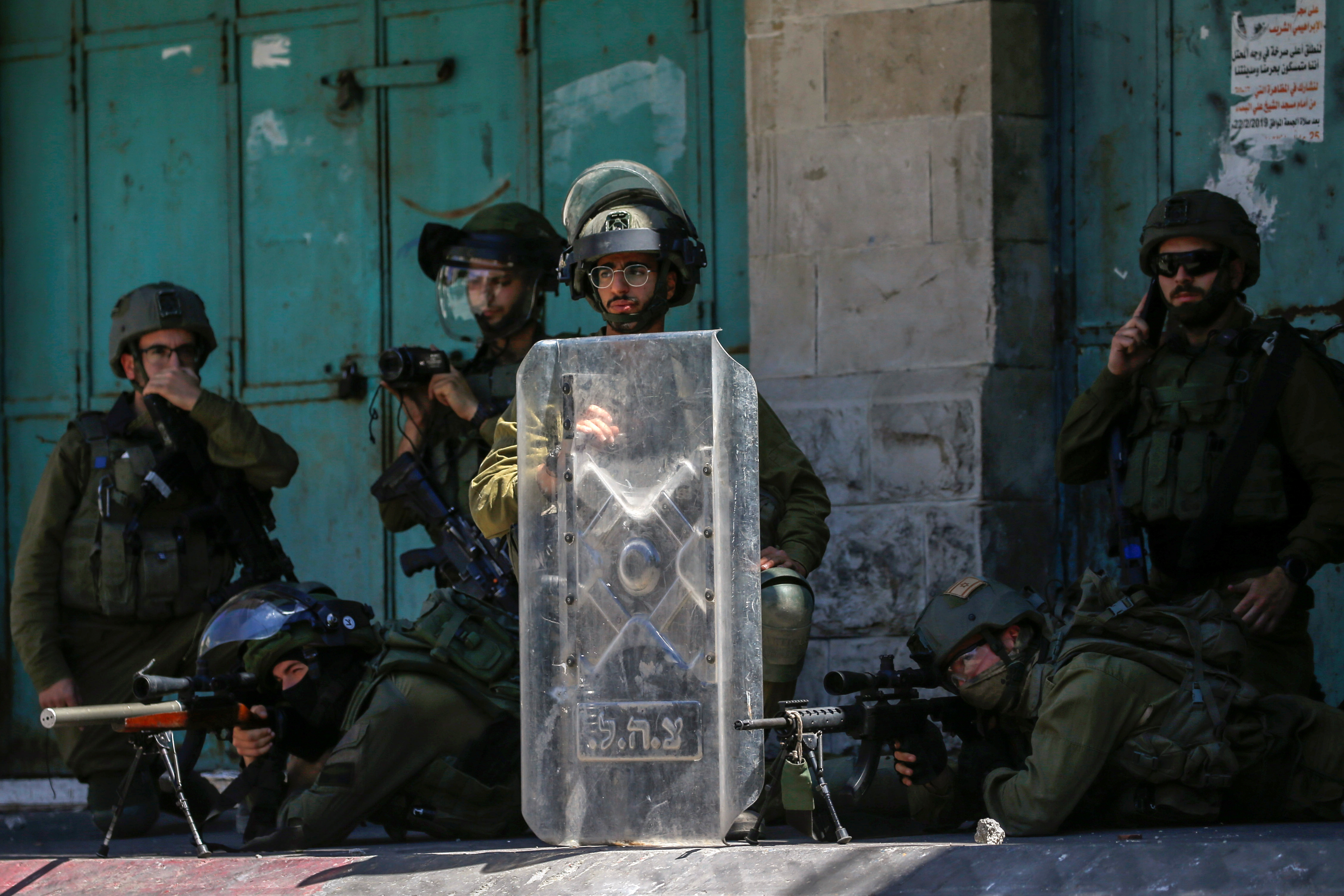 Israeli soldiers aim their weapons at Palestinian demonstrators
