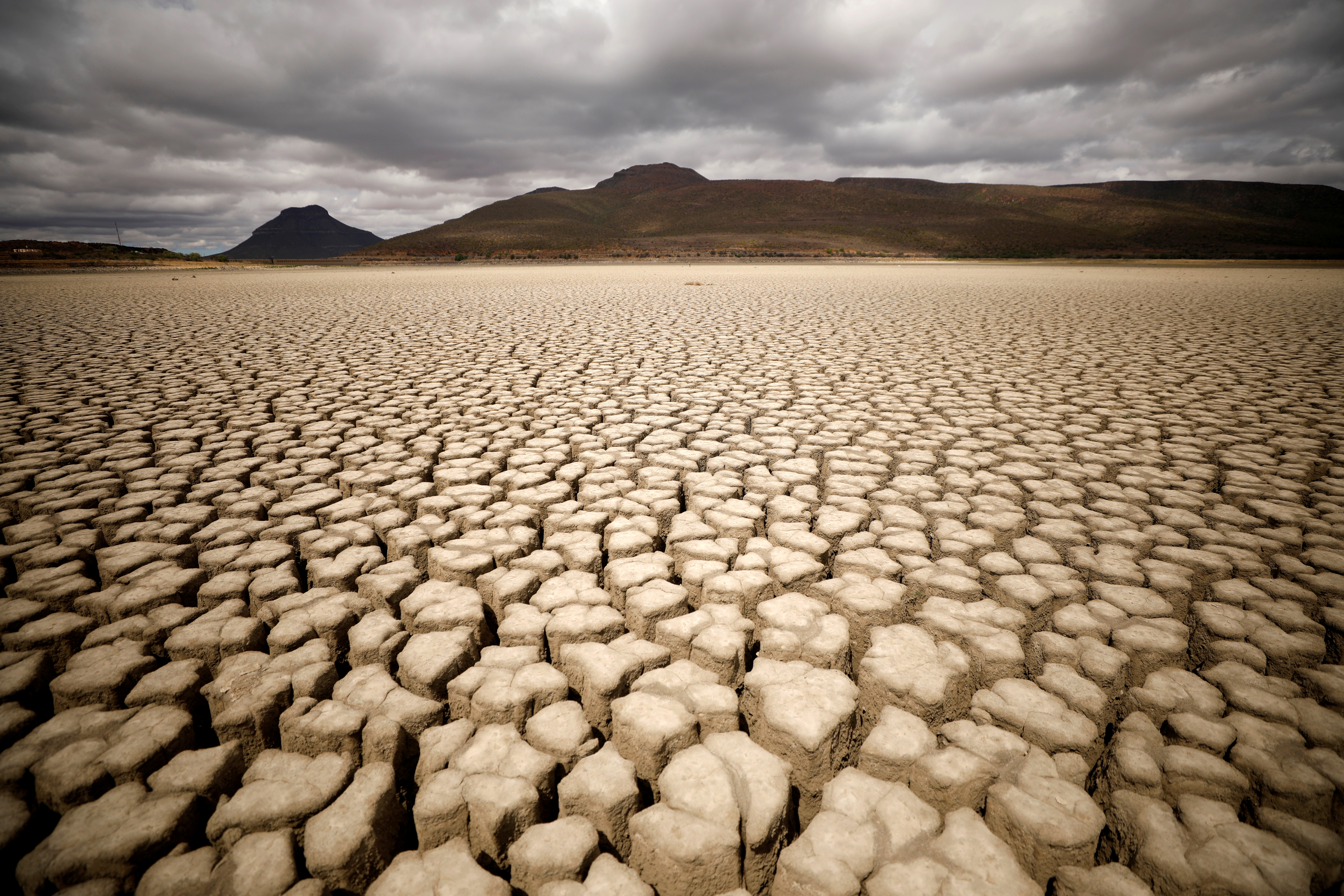 Clouds gather but produce no rain as cracks are seen in the dried-up municipal dam in drought-stricken Graaff-Reinet, South Africa