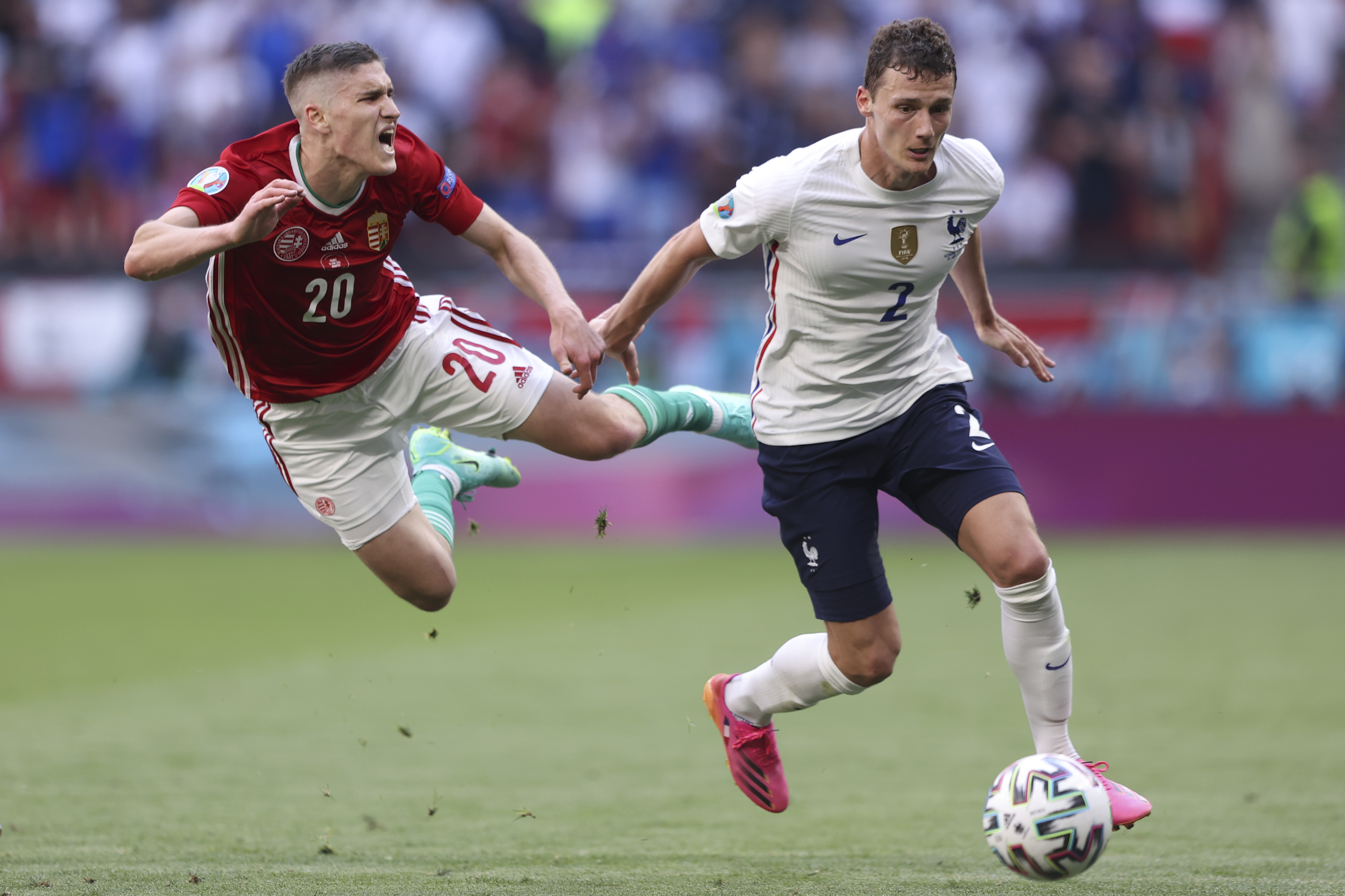 Hungary’s Roland Sallai is airborne as he challenges for the ball with France’s Benjamin Pavard