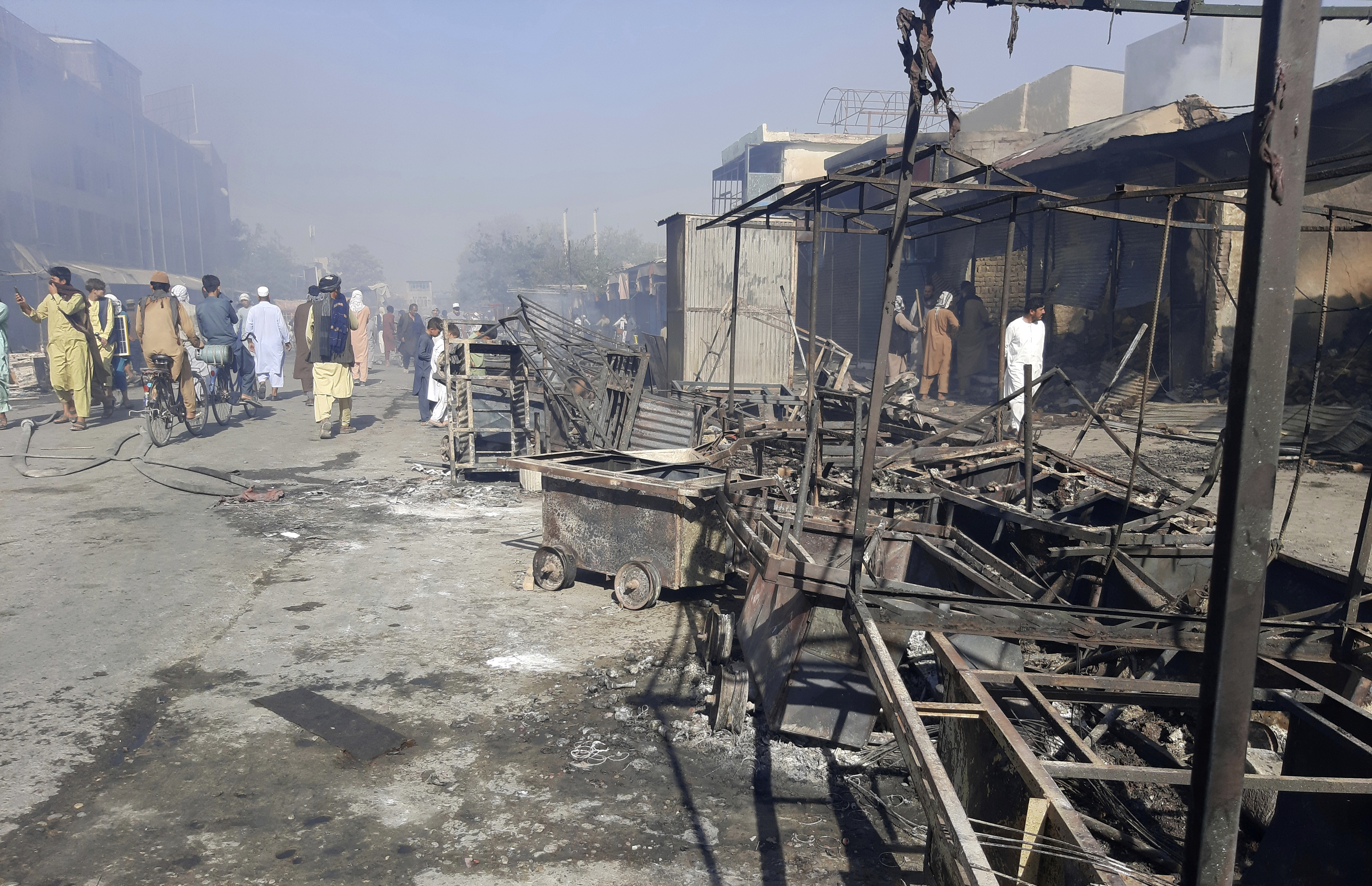 People inspect damaged shops after fighting between the Taliban and Afghan security forces in Kunduz city
