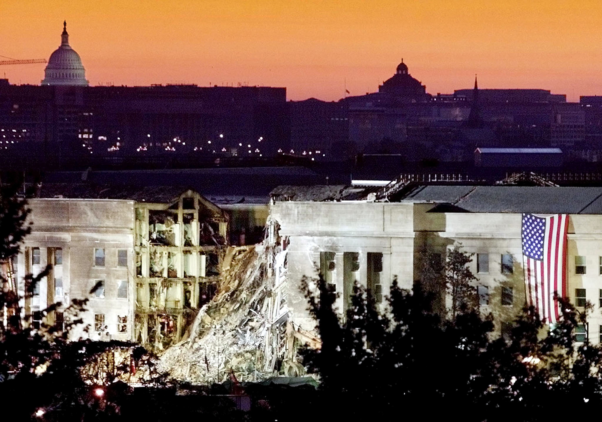 The damaged area of the Pentagon building, where a commercial airliner slammed into it on September 11, is seen in the early morning at sunrise with the US Capitol building in the background, on September 16, 2001