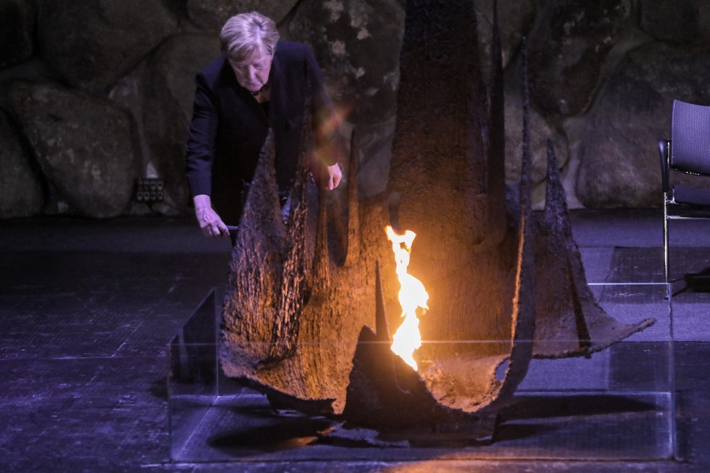 Merkel increases the eternal flame at the Hall of Remembrance at the Yad Vashem Holocaust Museum in Jerusalem [AFP]