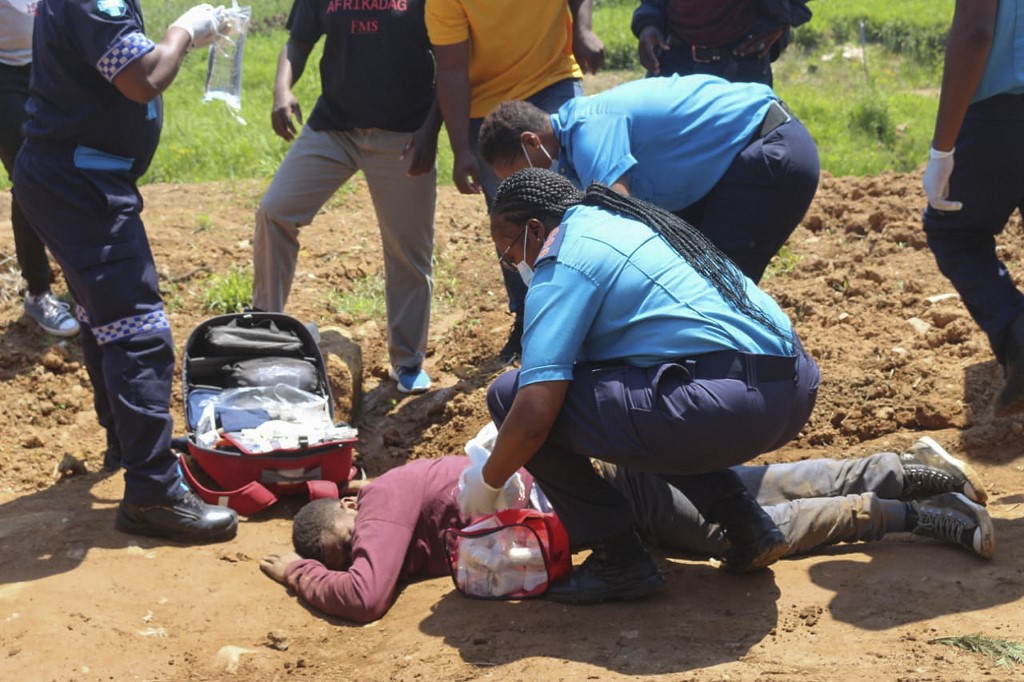 Paramedics tend to a person who was injured by police during protests in Mbabane [AFP]