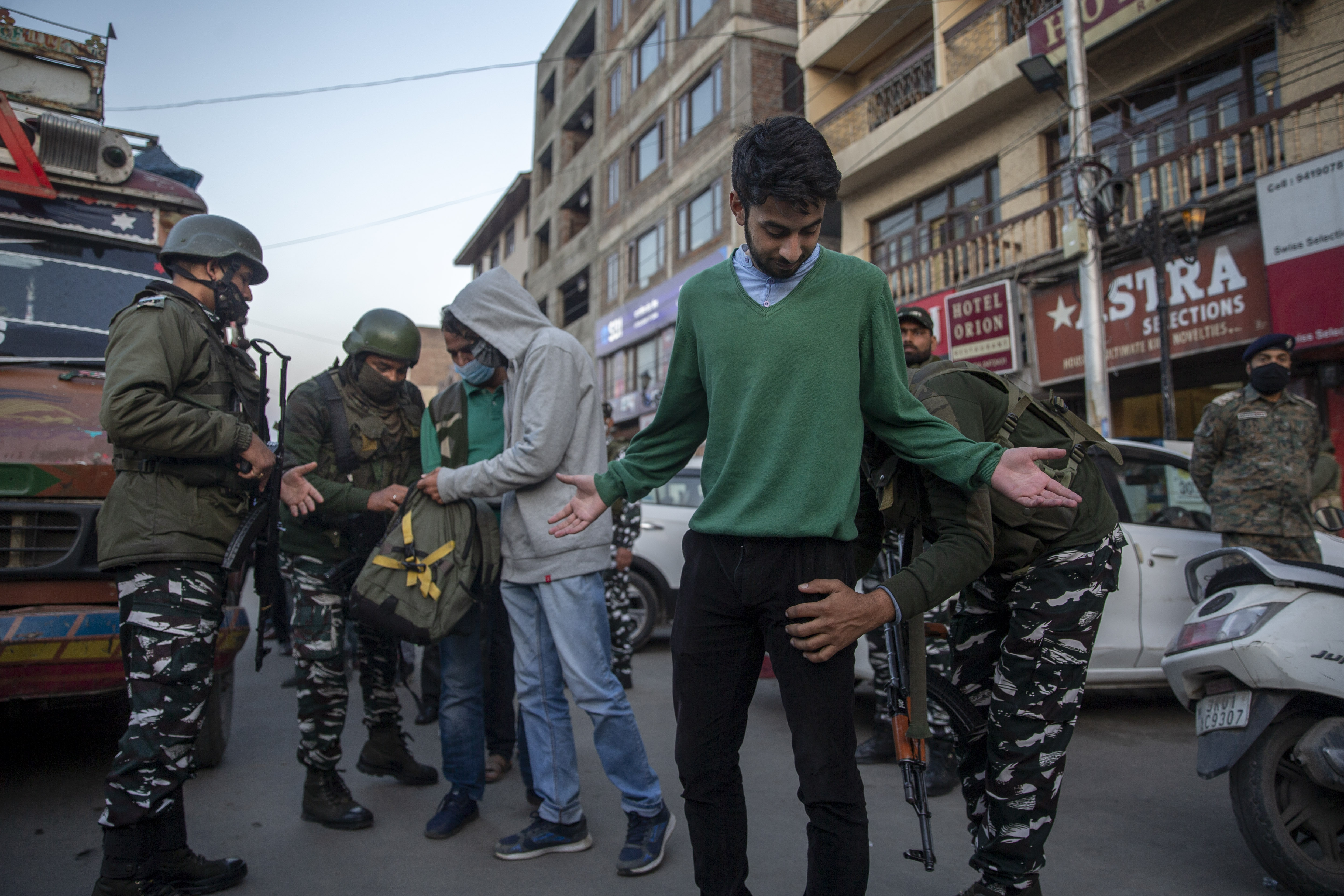 Indian paramilitary soldiers frisk Kashmiris during a surprise check operation in Srinagar