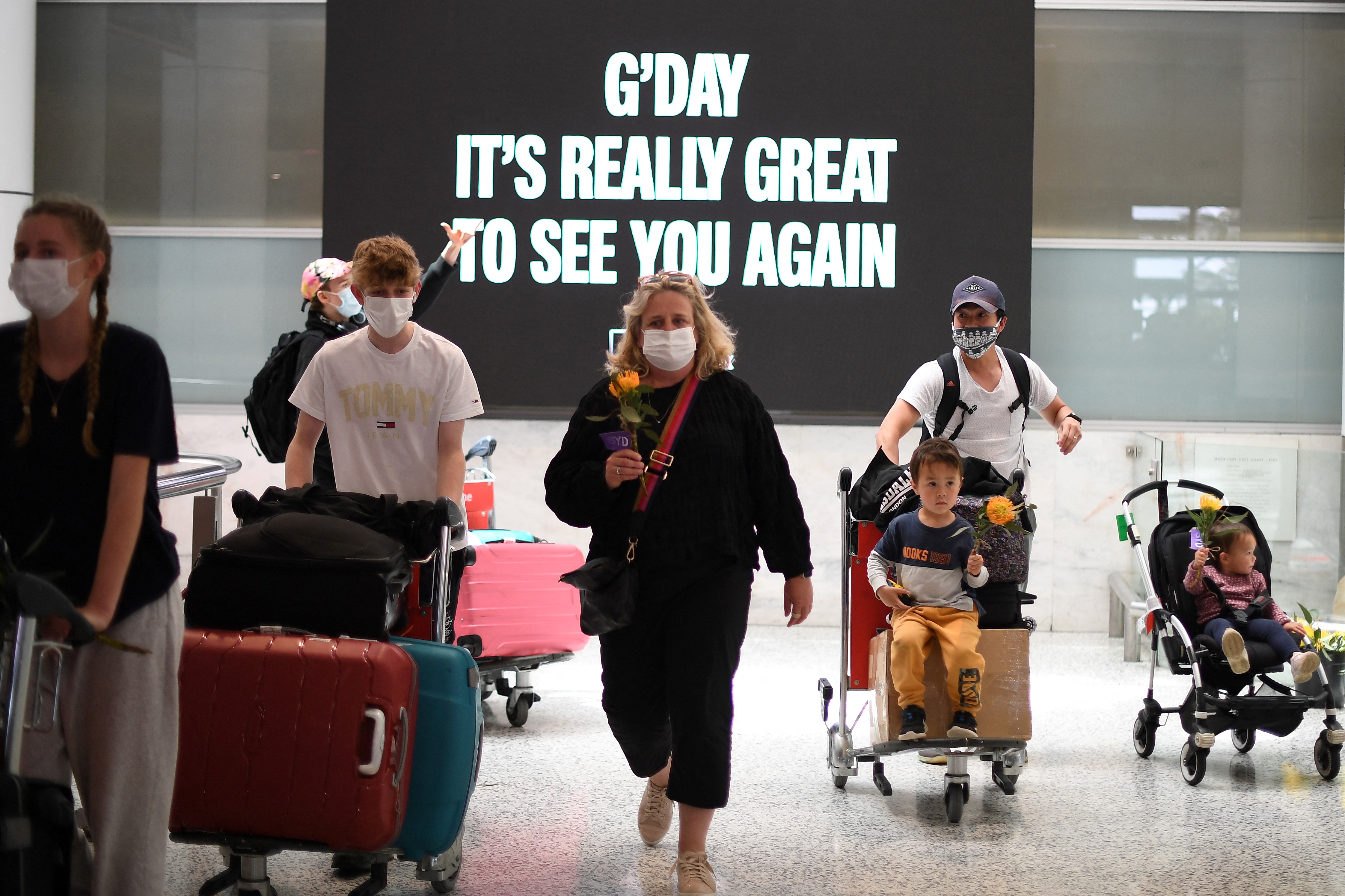 Families walk out of the arrivals hall at Sydney’s international airport on November 1, 2021