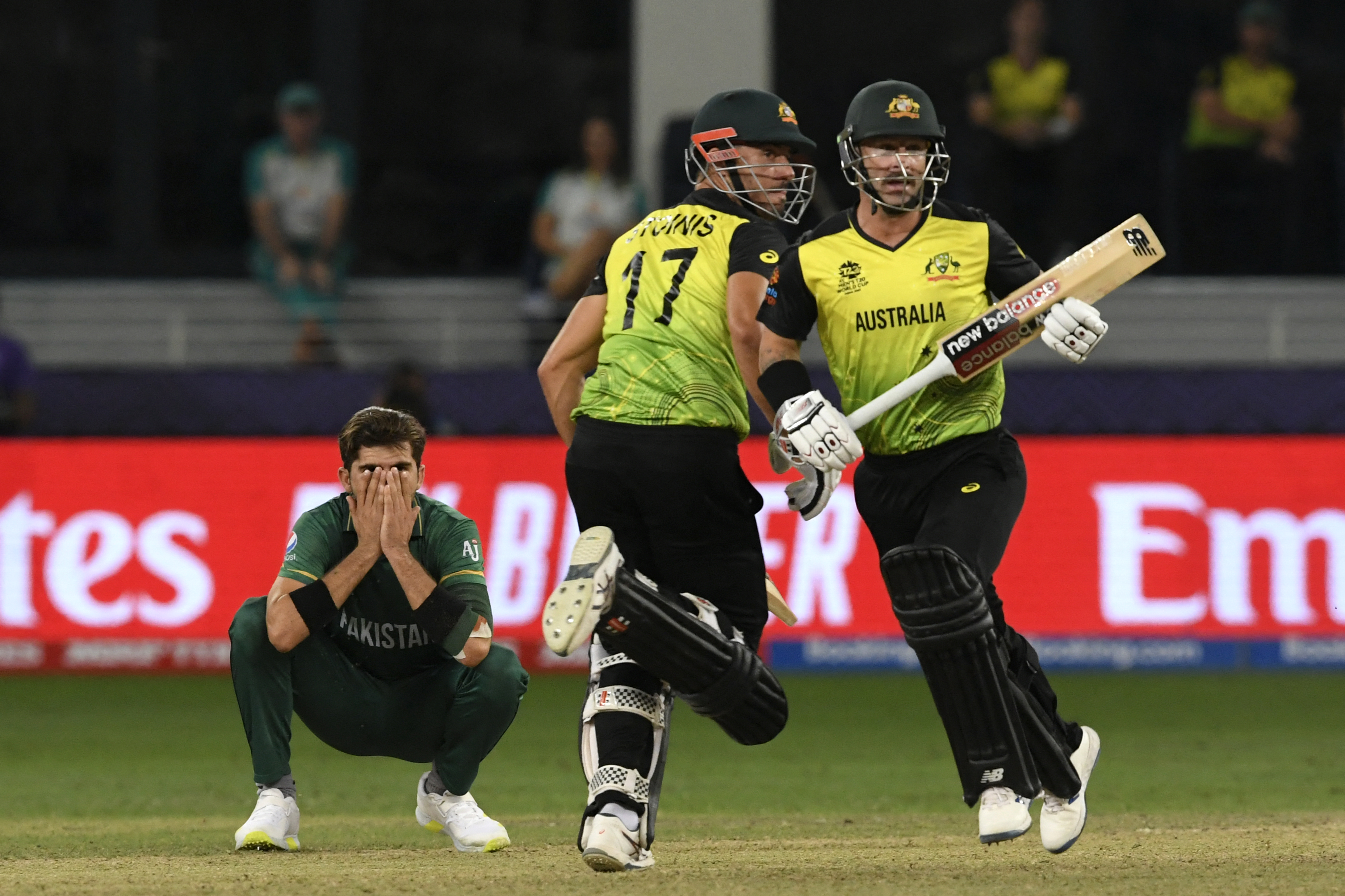 Pakistan’s Shaheen Shah Afridi (L) reacts as Australia’s Marcus Stoinis (C) and Matthew Wade run between the wickets during the ICC mens Twenty20 World Cup semi-final match between Australia and Pakistan at the Dubai International Cricket Stadium in Dubai on November 11, 2021