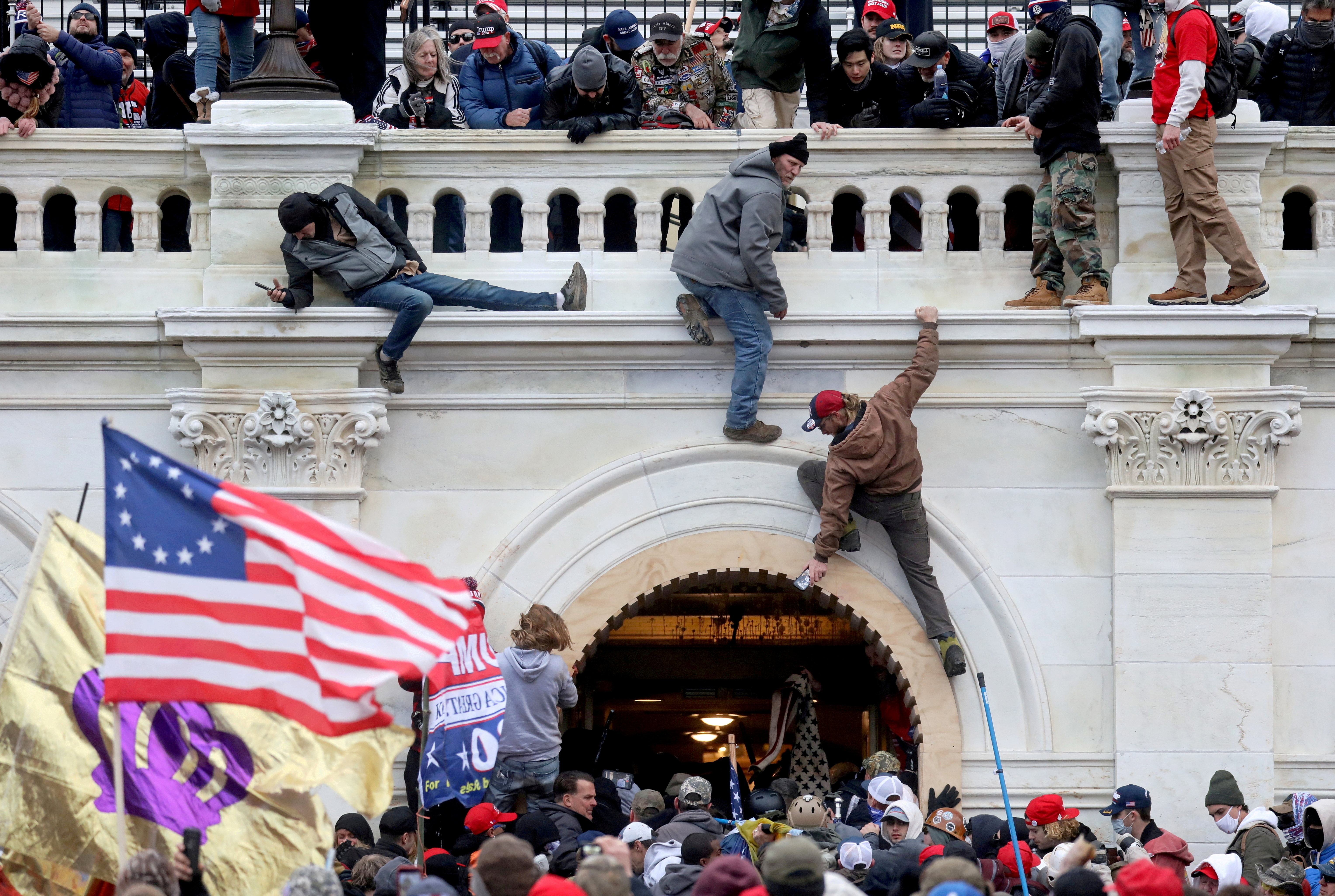 A mob of supporters of US President Donald Trump fight with members of law enforcement at a door they broke open as they storm the US Capitol Building in Washington on January 6, 2021