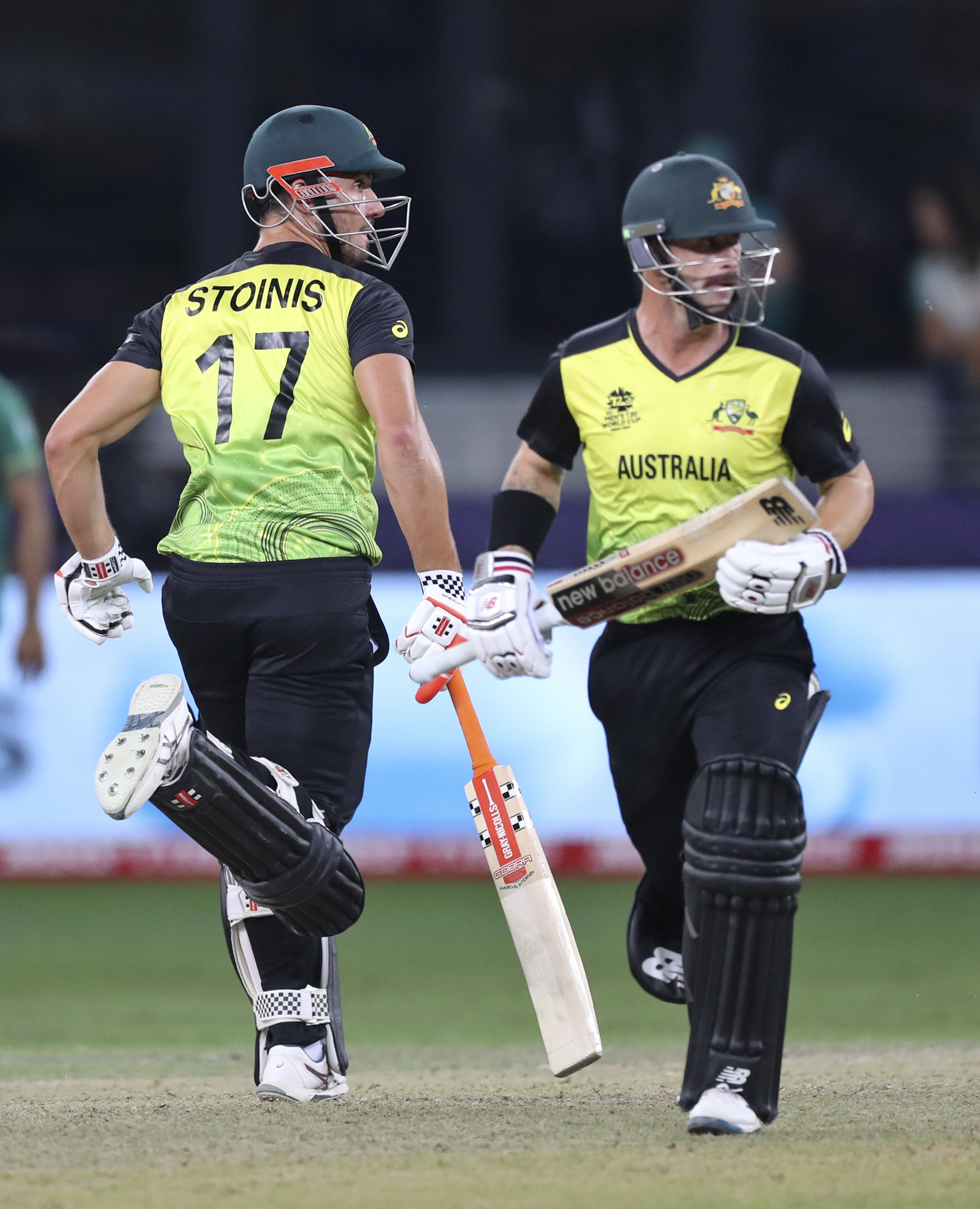 Australia’s Marcus Stoinis, left, and Matthew Wade run between the wickets during the Cricket Twenty20 World Cup semi-final match between Pakistan and Australia in Dubai, UAE, Thursday, November 11, 2021.