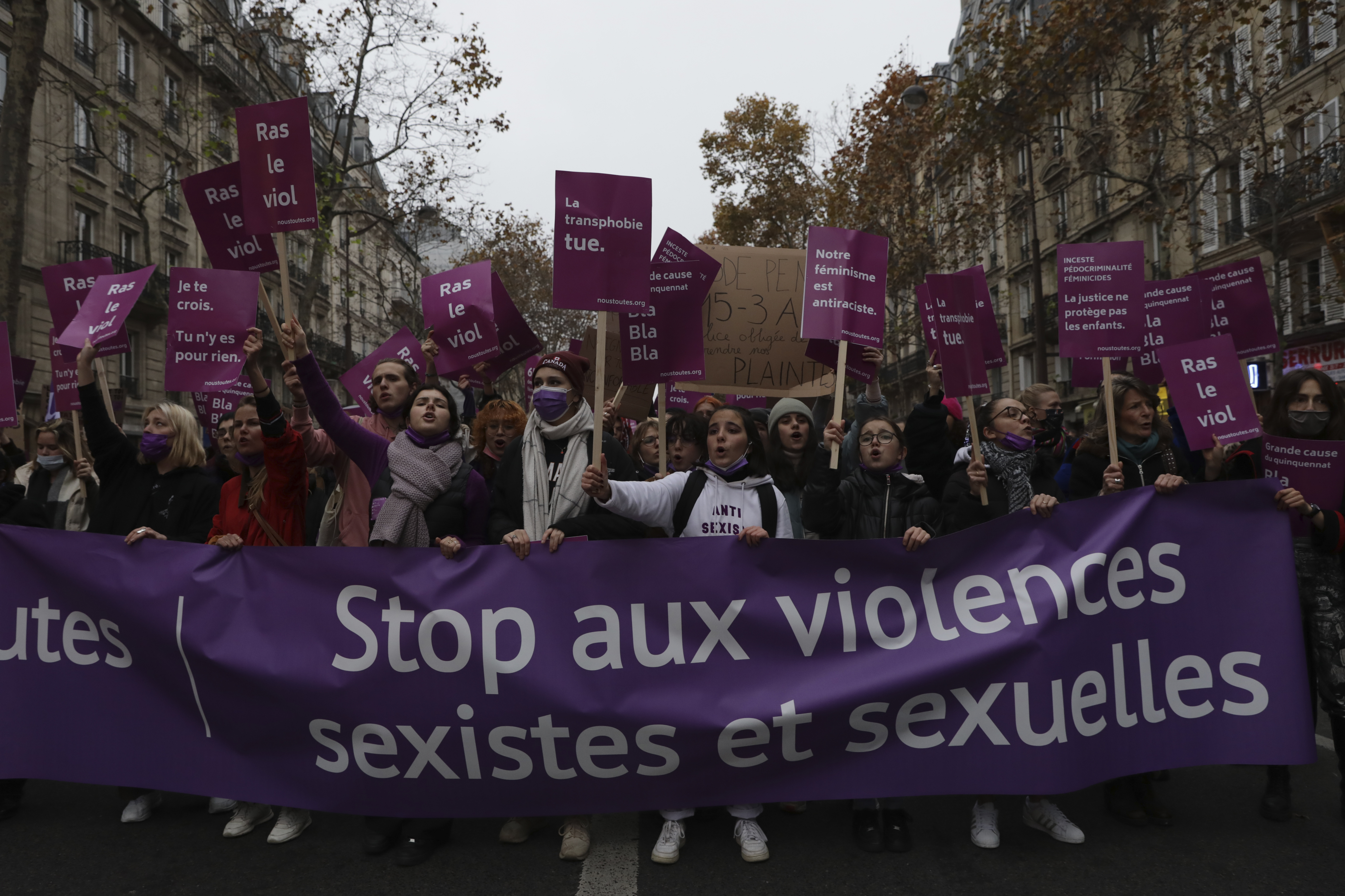 Women demonstrating behind a banner reading ‘Stop to sexist and sexual violence’