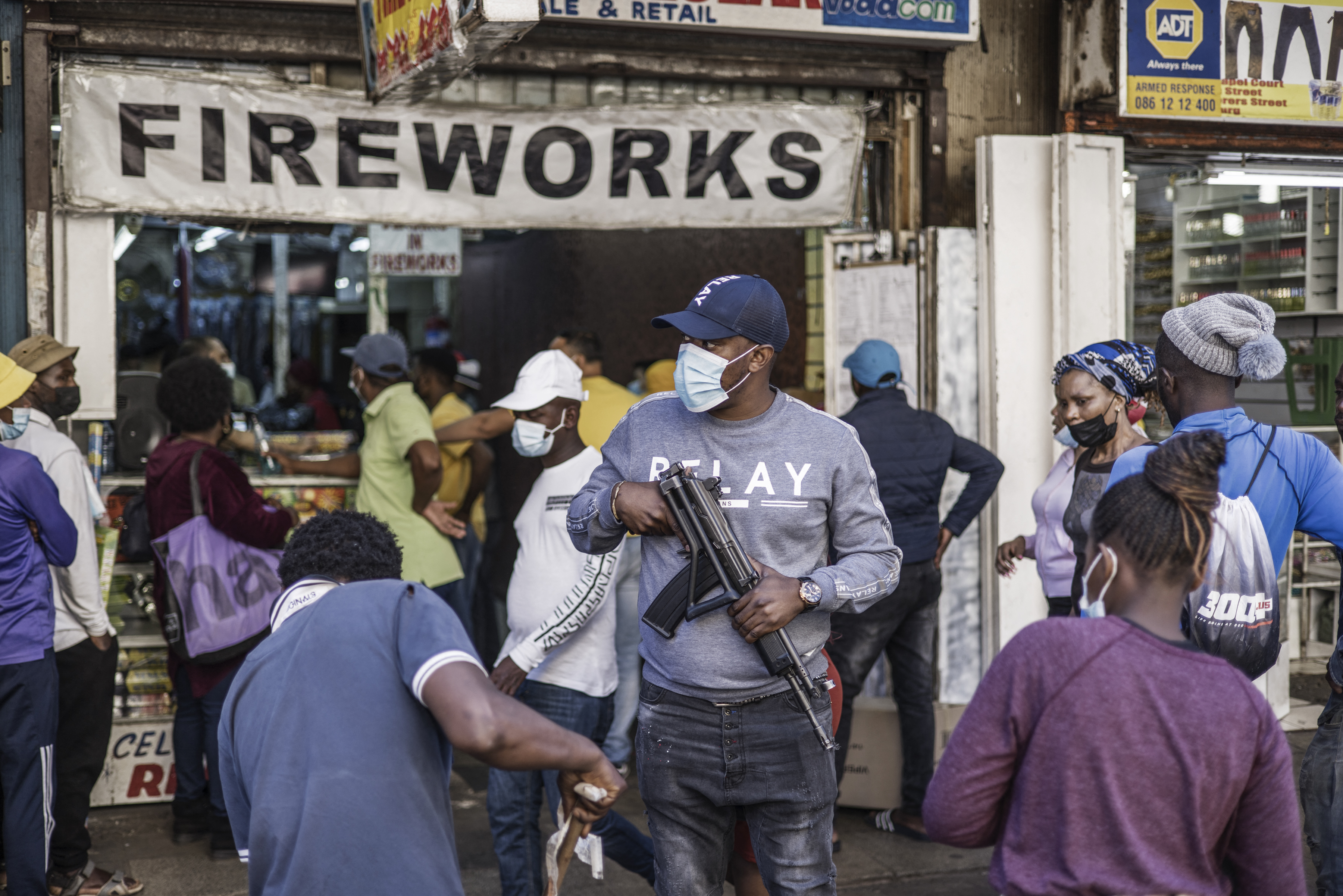 An undercover police officer is seen as customers queue to buy fireworks outside the St Mary Cathedral in Johannesburg, South Africa before New Year’s Eve celebrations