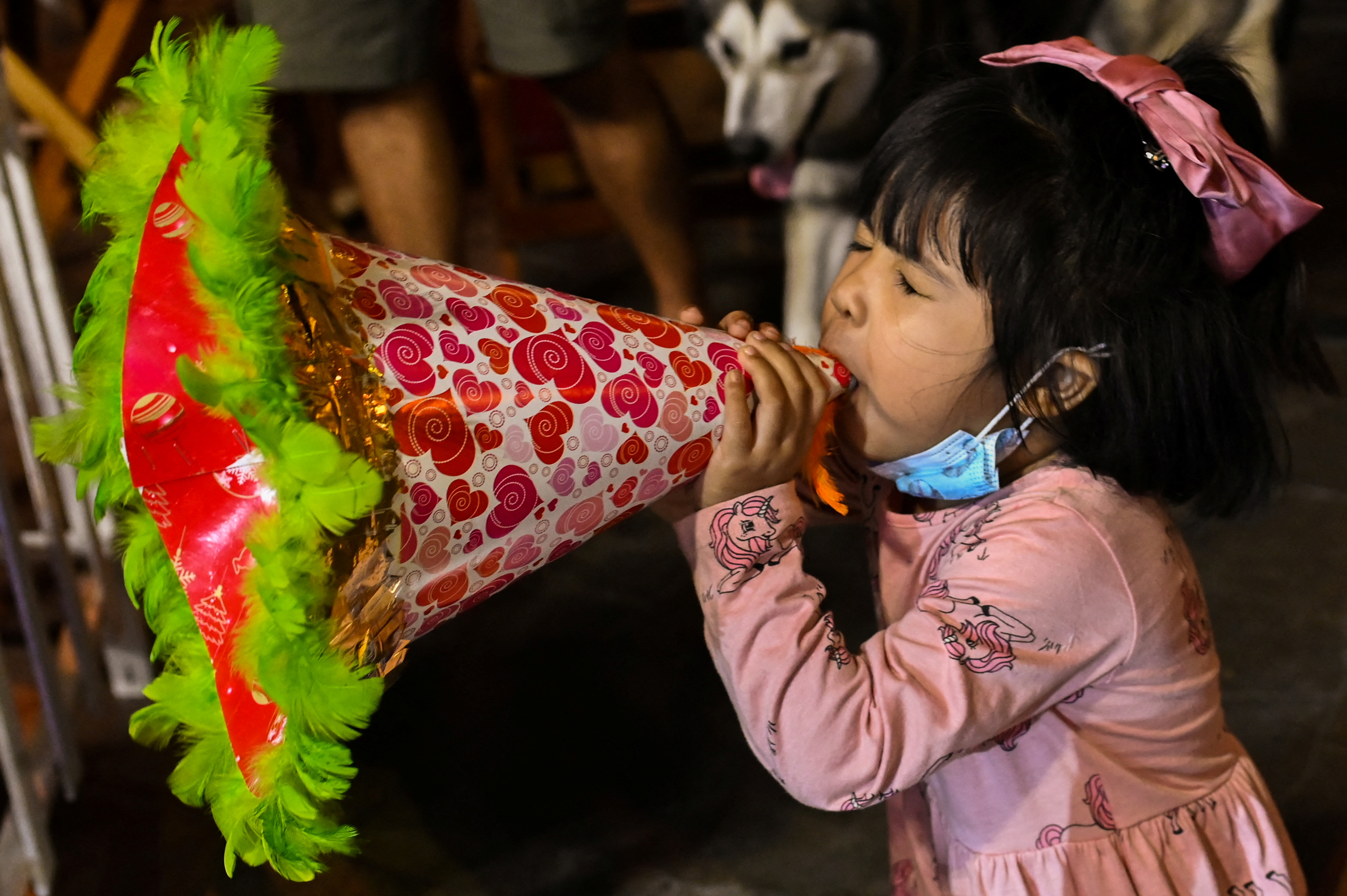 A child blows a trumpet during the New Year’s Eve countdown at a mall in Quezon City, a suburb of the Philippine capital Manila