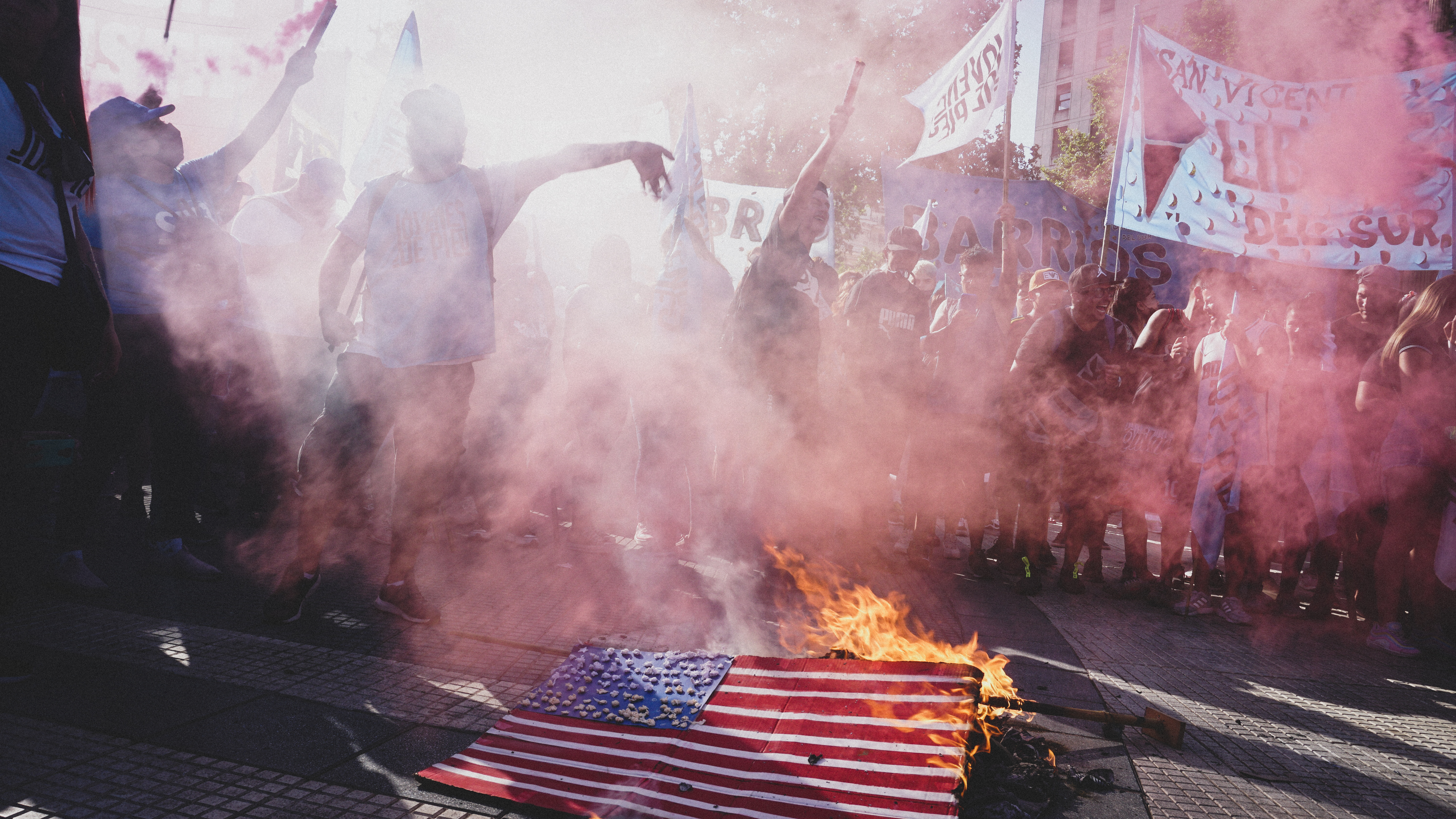 Members of social organizations in Argentina gathered around a burning cardboard rendition of the US flag at an anti-IMF march in Buenos Aires, Argentina