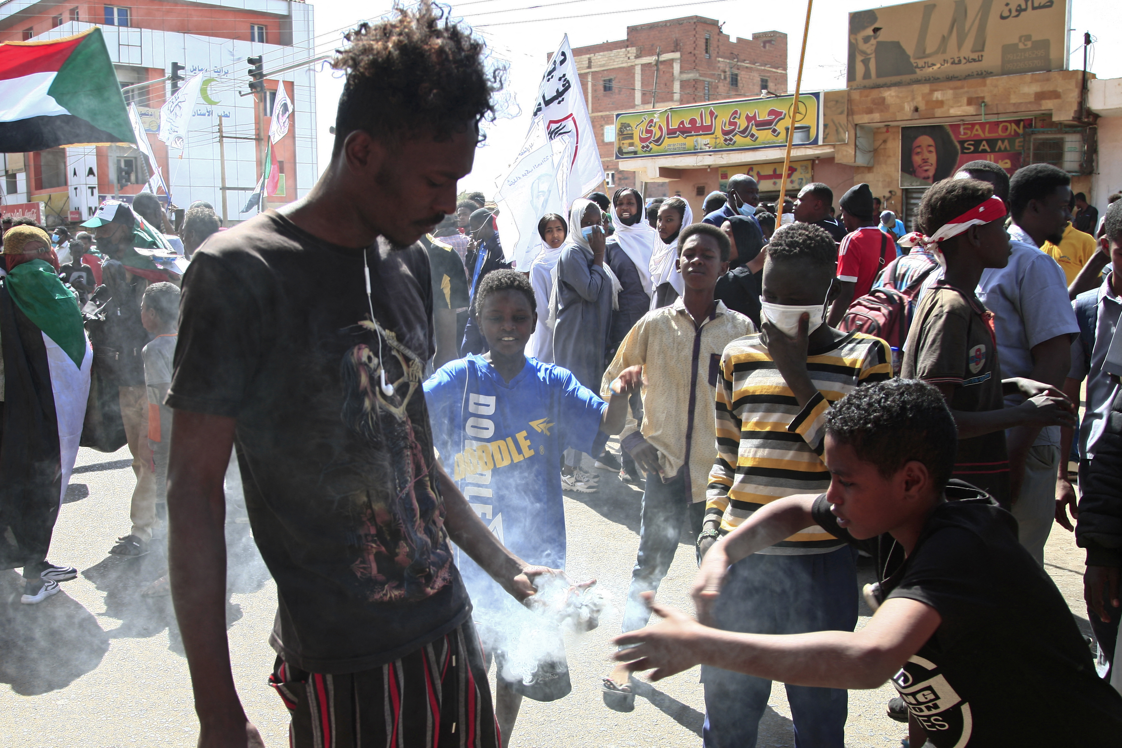 A Sudanese protester holds a tear gas fired by security forces during a rally against a military coup, south of the capital Khartoum