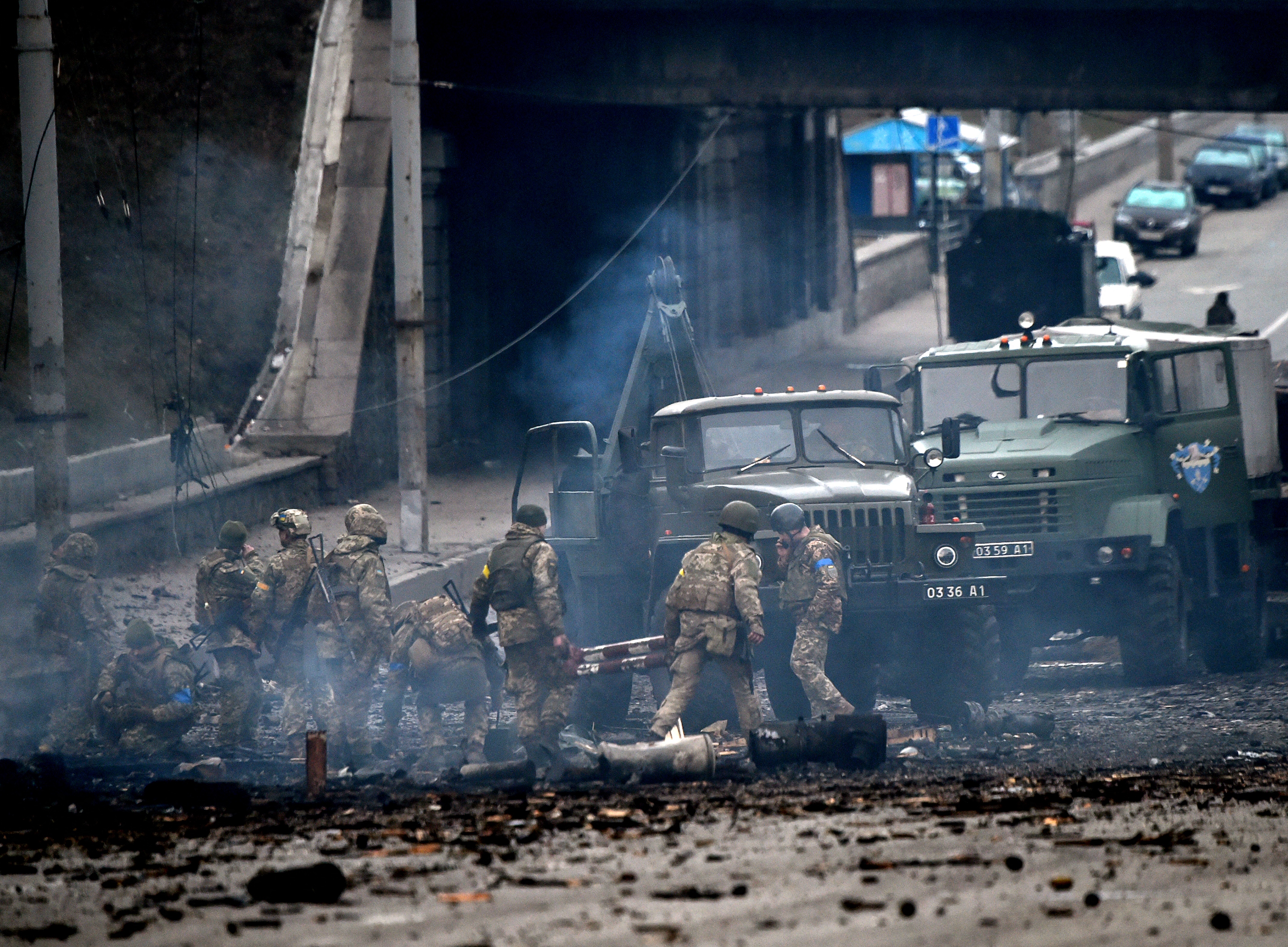 Ukrainian service members collect unexploded shells
