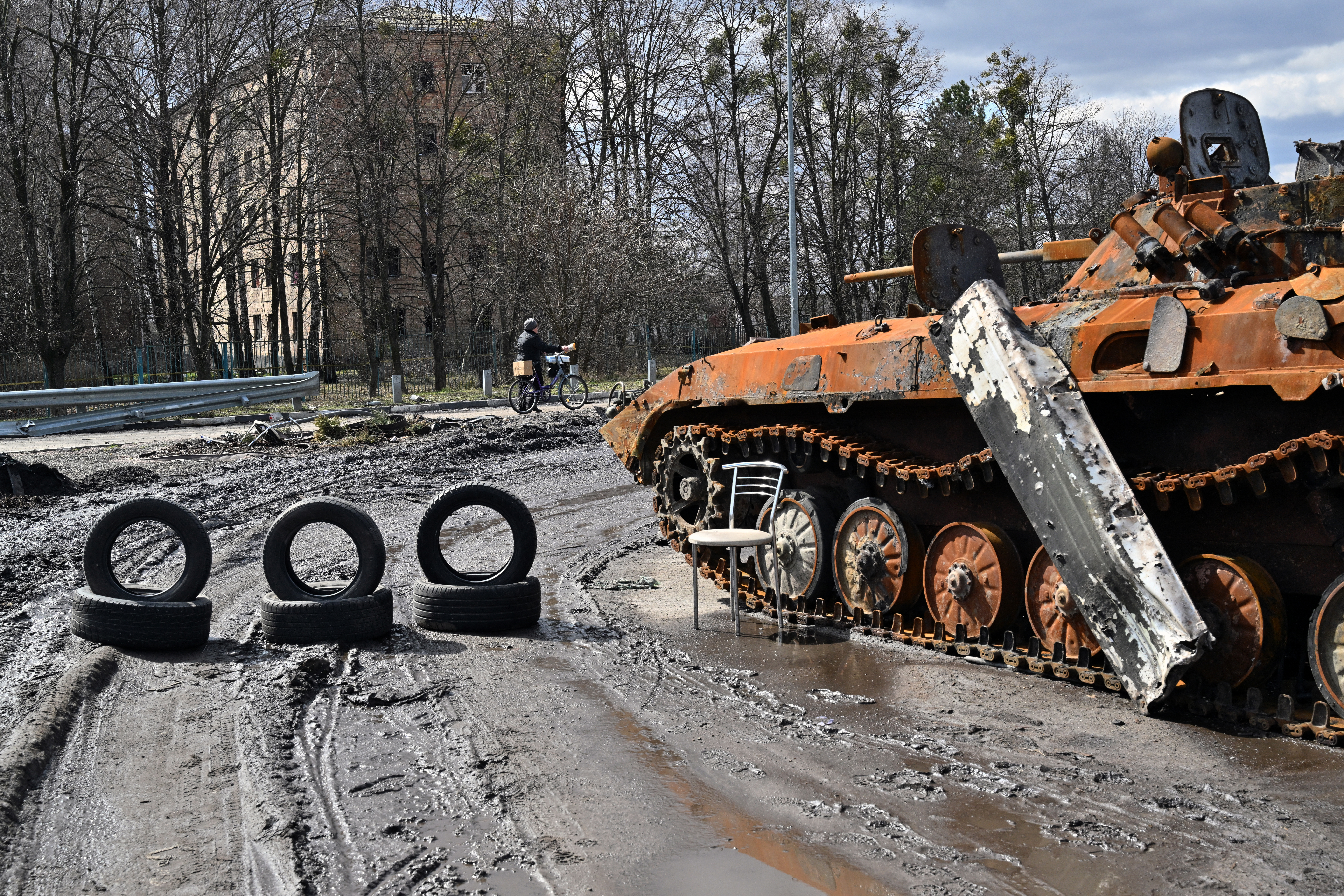 People walk past destroyed buildings in the town of Borodianka