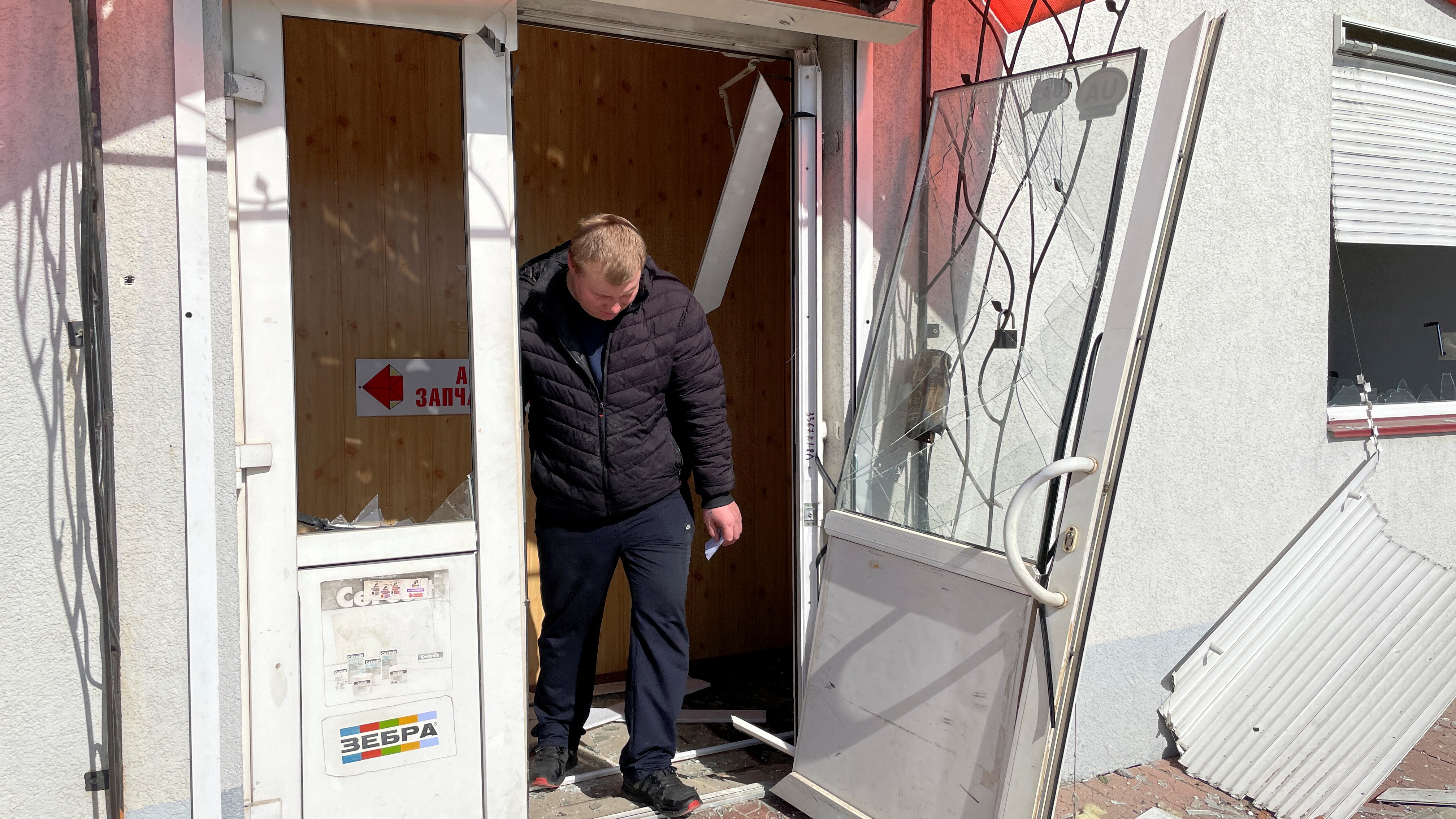 A man exits a building in Kyiv damaged by a Russian cruise missile strike