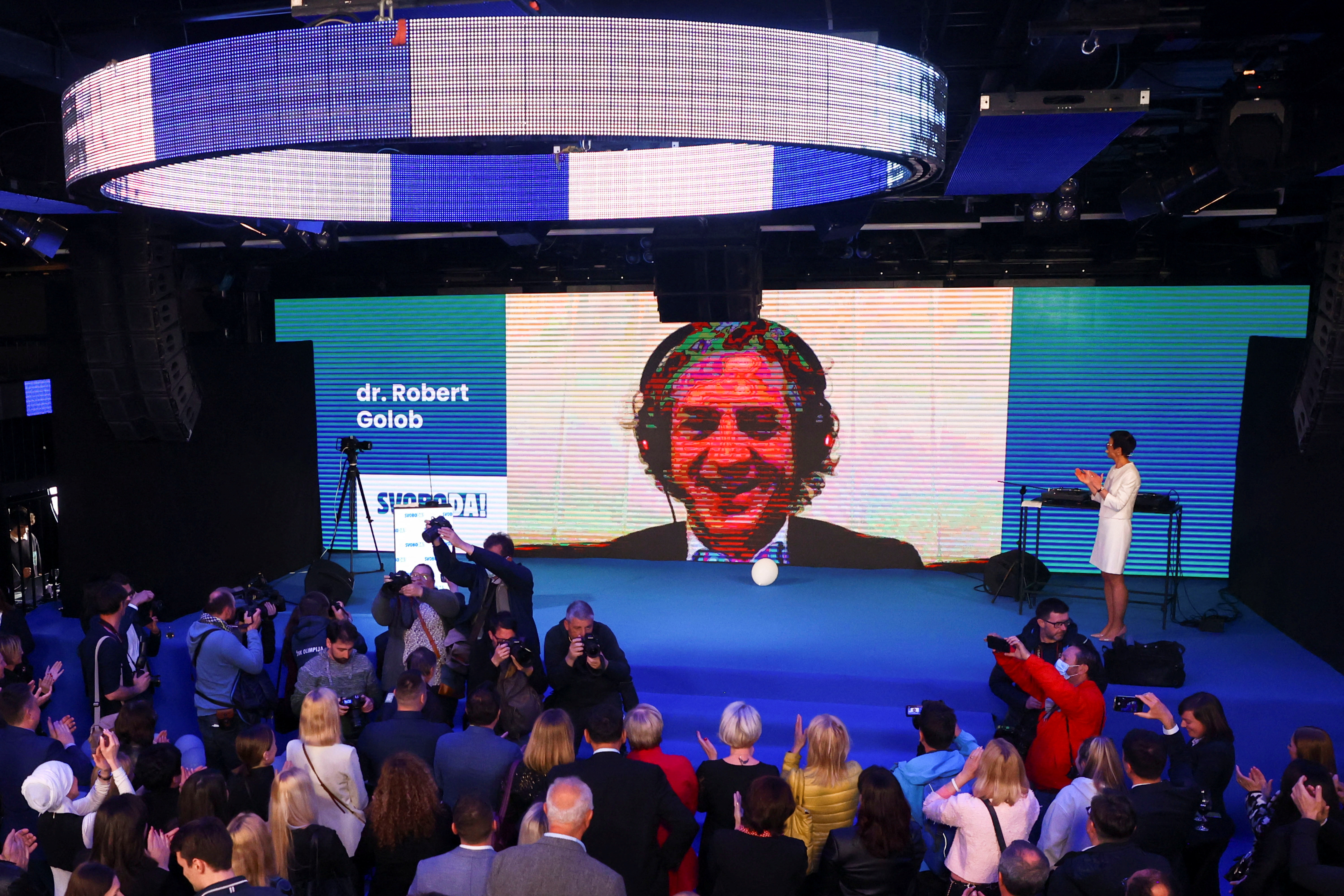 Golob appears on screen at the party base as people cheer while waiting for the results of the parliamentary election in Ljubljana